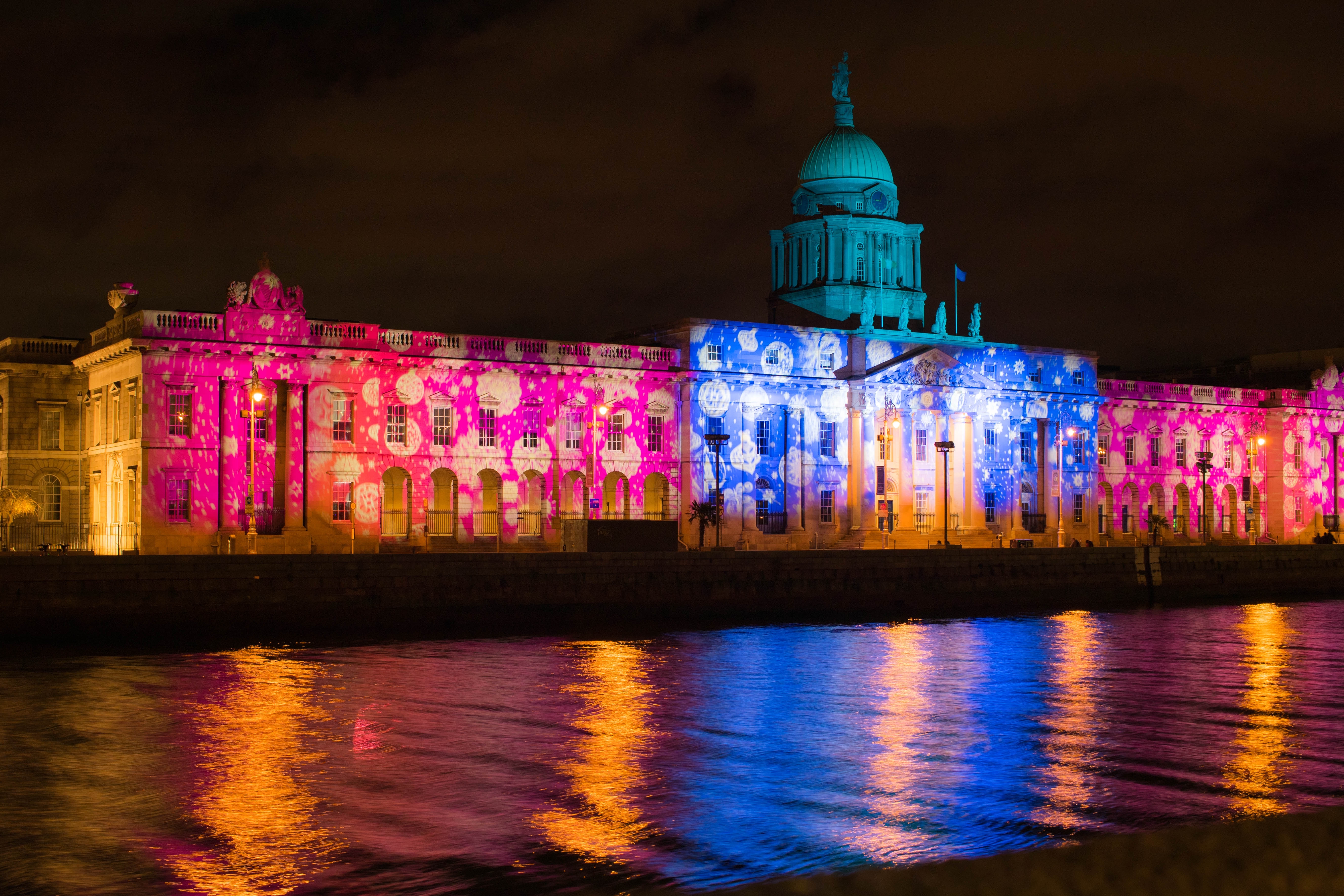 Custom House i Dublin oplyst med spektakulære farverige julelys der kaster et smukt skær over floden Liffey