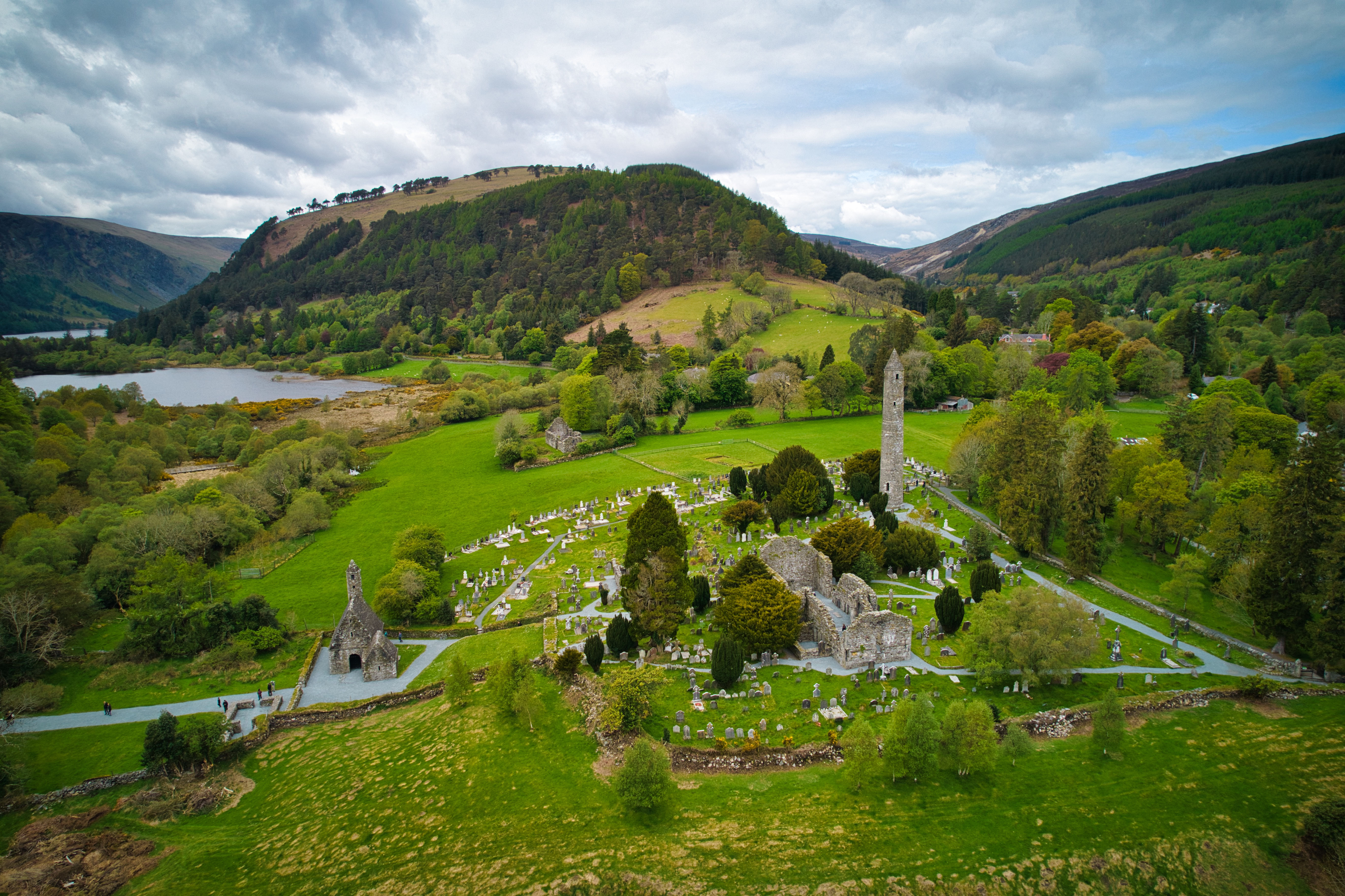 Betagende landskab med Glendalough klosterruiner og det historiske runde tårn ved den fredelige sø i Wicklow bjergene, Irland
