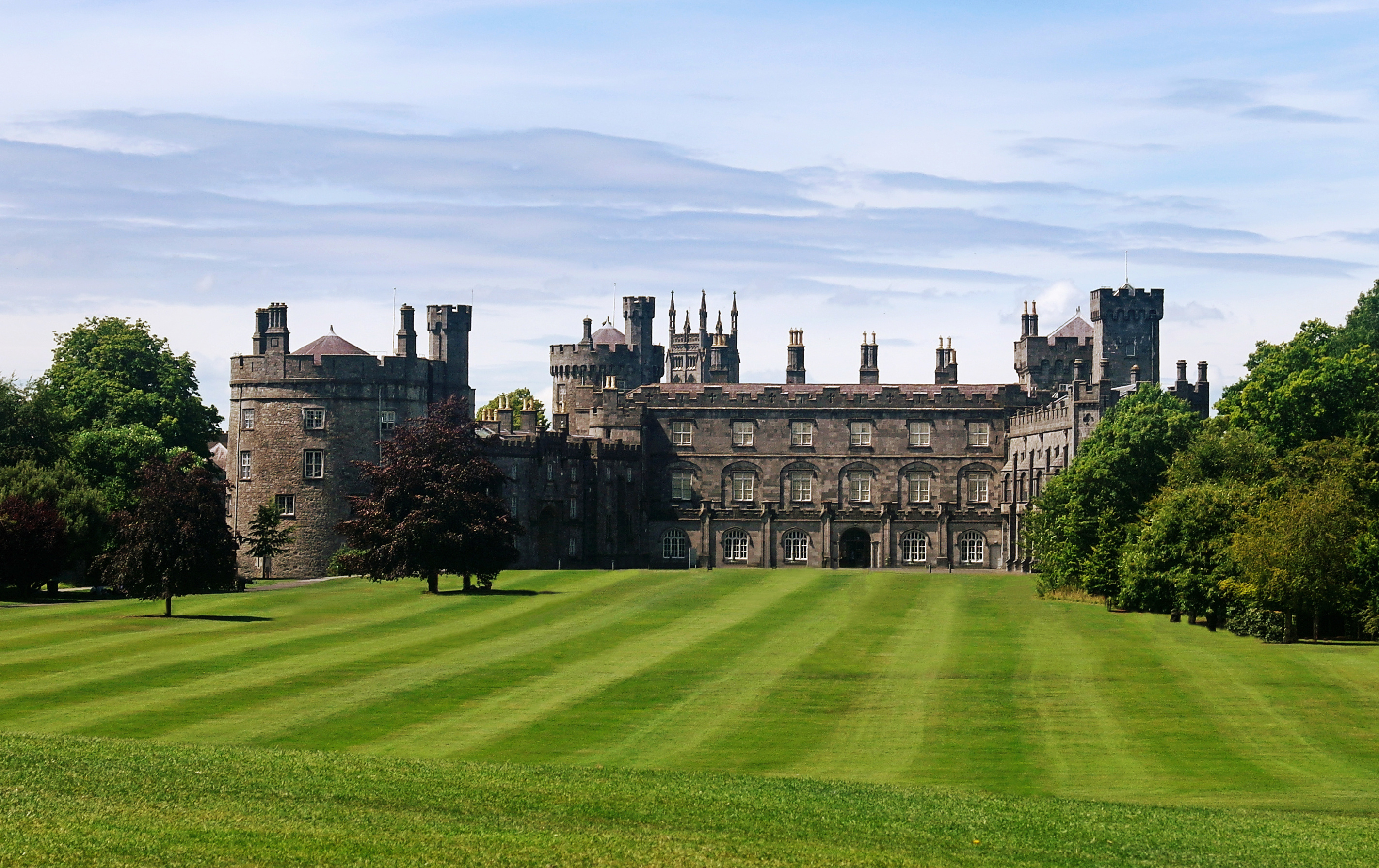 Middelalderslottet Kilkenny Castle i Irland med karakteristiske tårne og velholdt grøn slotspark
