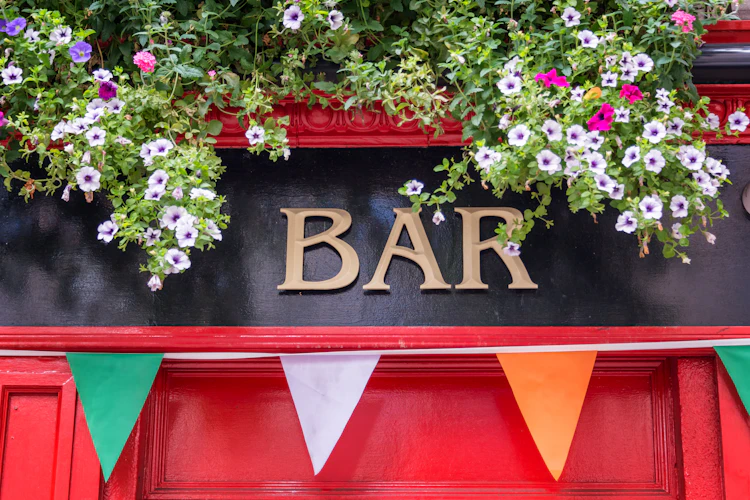 Autentisk irsk pubskilt i Dublin med smukke blomster i grøn, hvid og orange, symboliserende irsk tradition