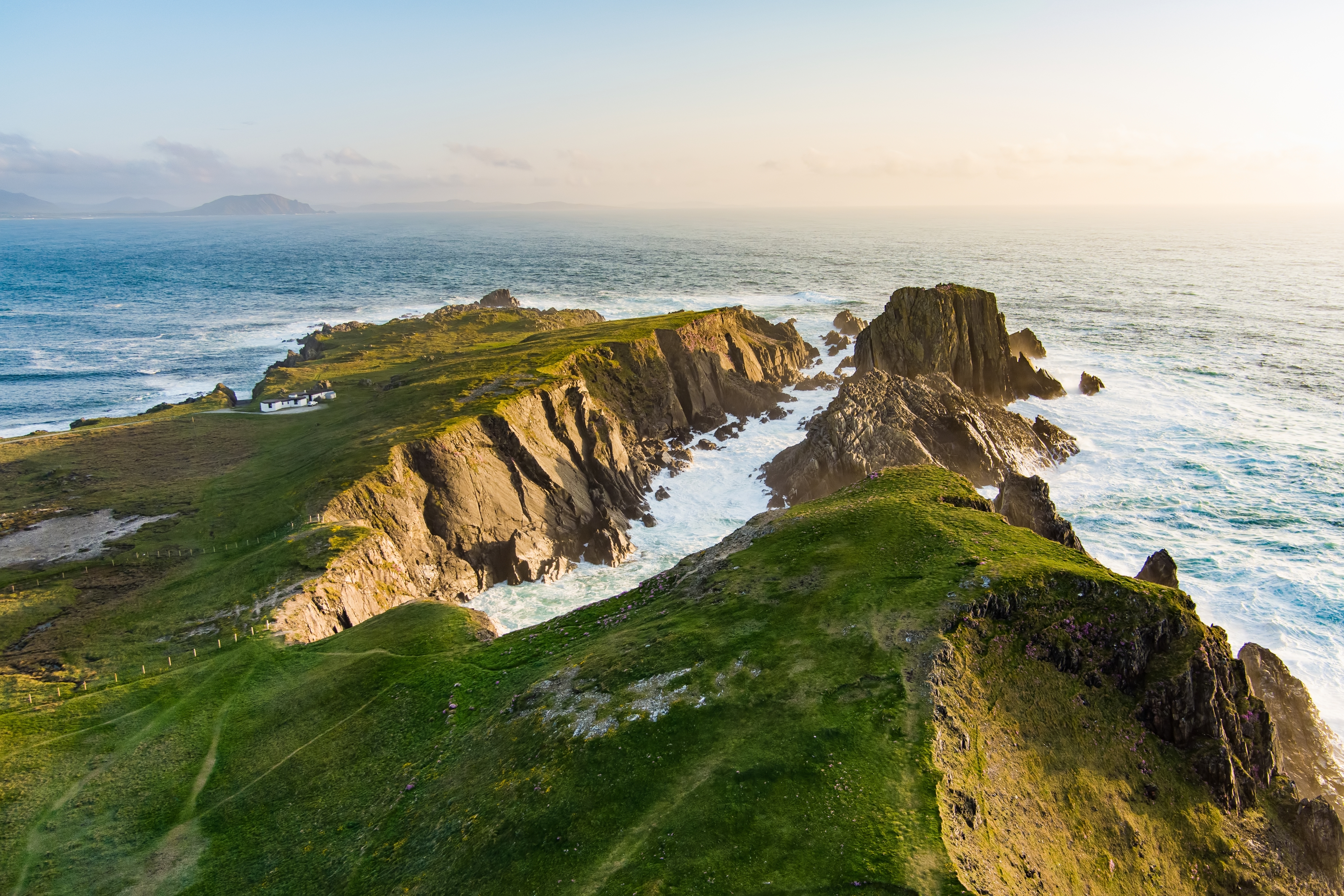 Irske kystklipperne badet i gyldent lys under golden hour ved atlanterhavet