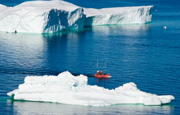 Arktisk udsigt med rødt skib og massive isbjerge ved Sermermiut, Ilulissat, Grønland