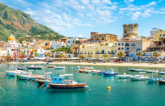 Malerisk panorama over Forio på Ischia med azurblåt vand, sandstrande og grønne bjerge, en skjult perle i Middelhavet nær Napoli