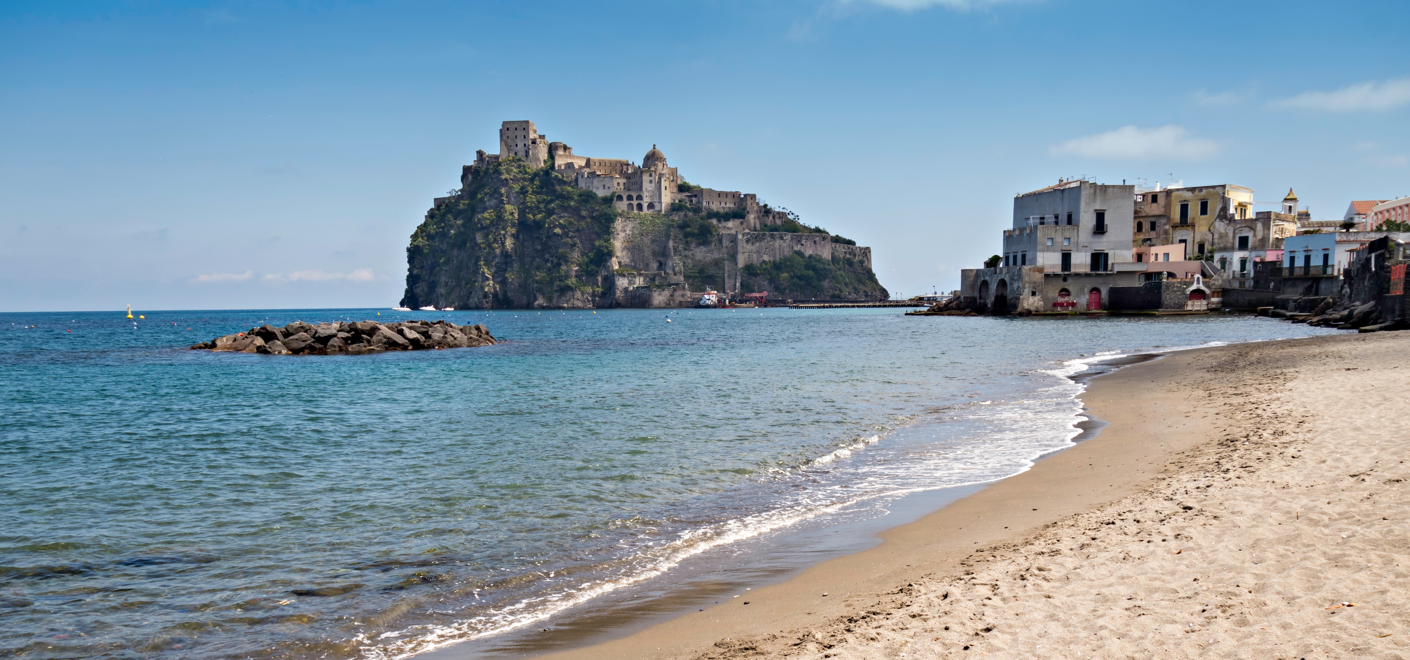 Idyllisk strandudsigt mod det middelalderlige Aragonesiske Slot på Ischia i Napoli-bugten, Syditalien