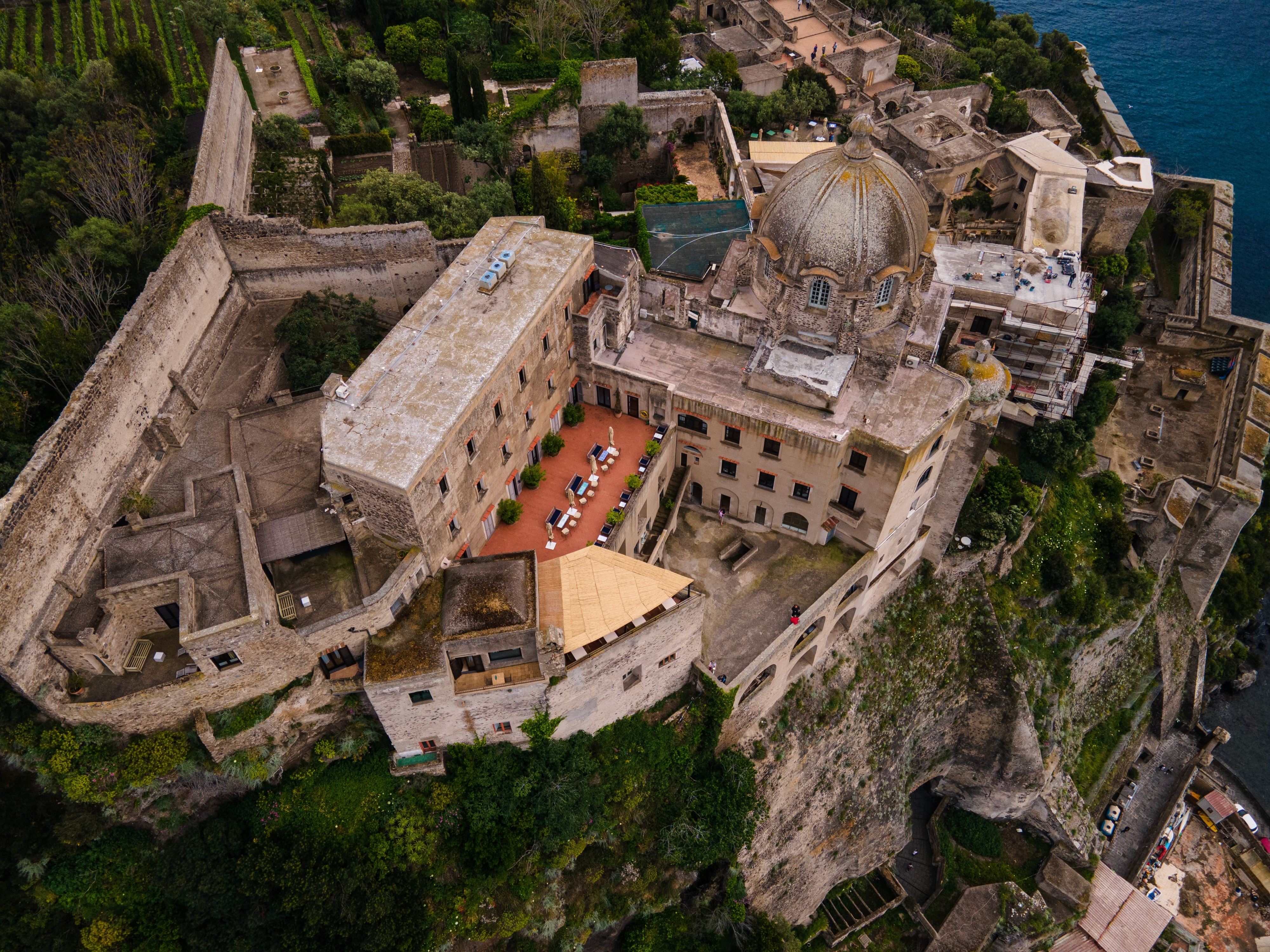 Malerisk dronefoto af den ikoniske Castello Aragonese fæstning på en lille ø ved Ischia, en historisk perle i det blå Middelhav nær Napoli