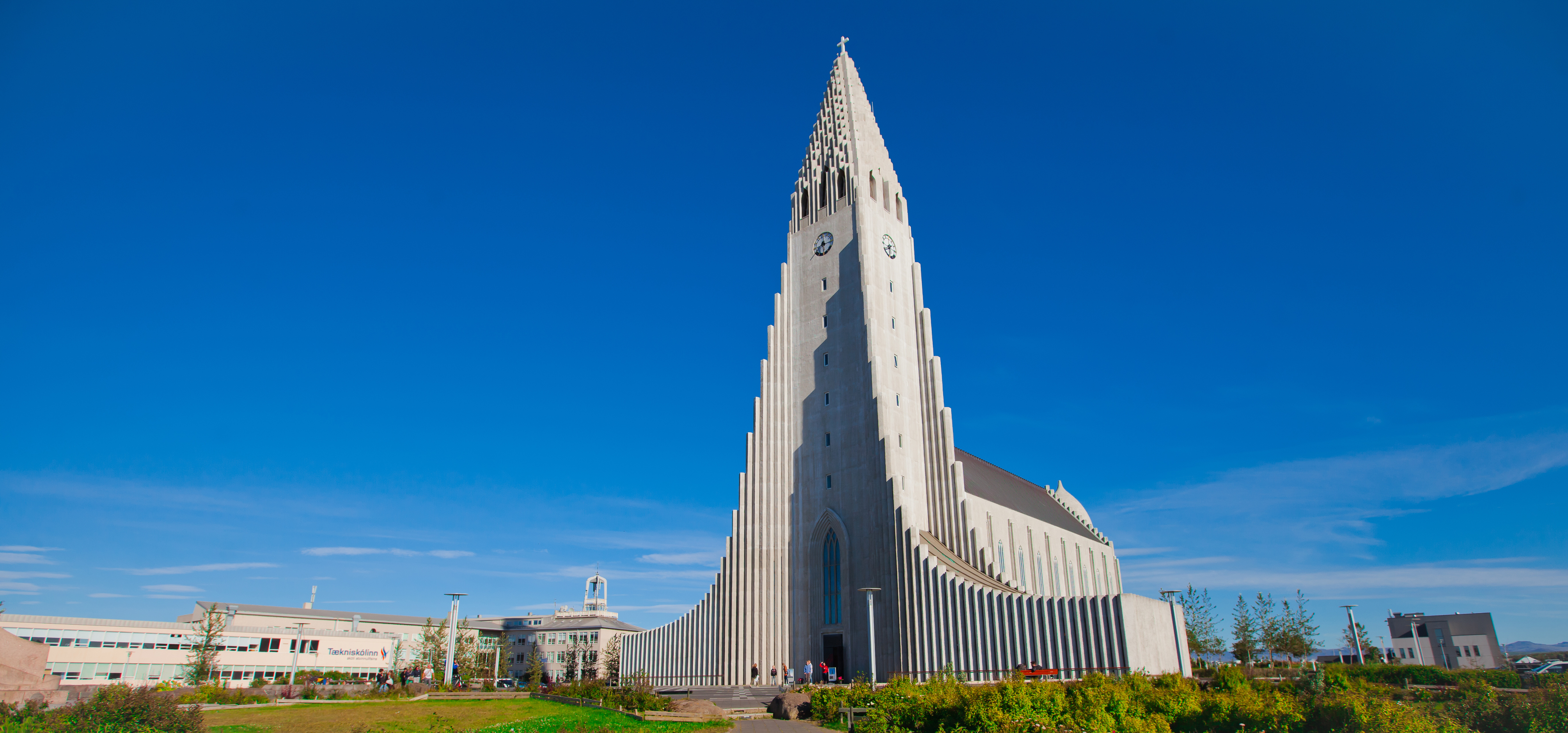 Den imponerende Hallgrimskirkja kirke i Reykjavik på Island set fra gadeplan mod blå himmel