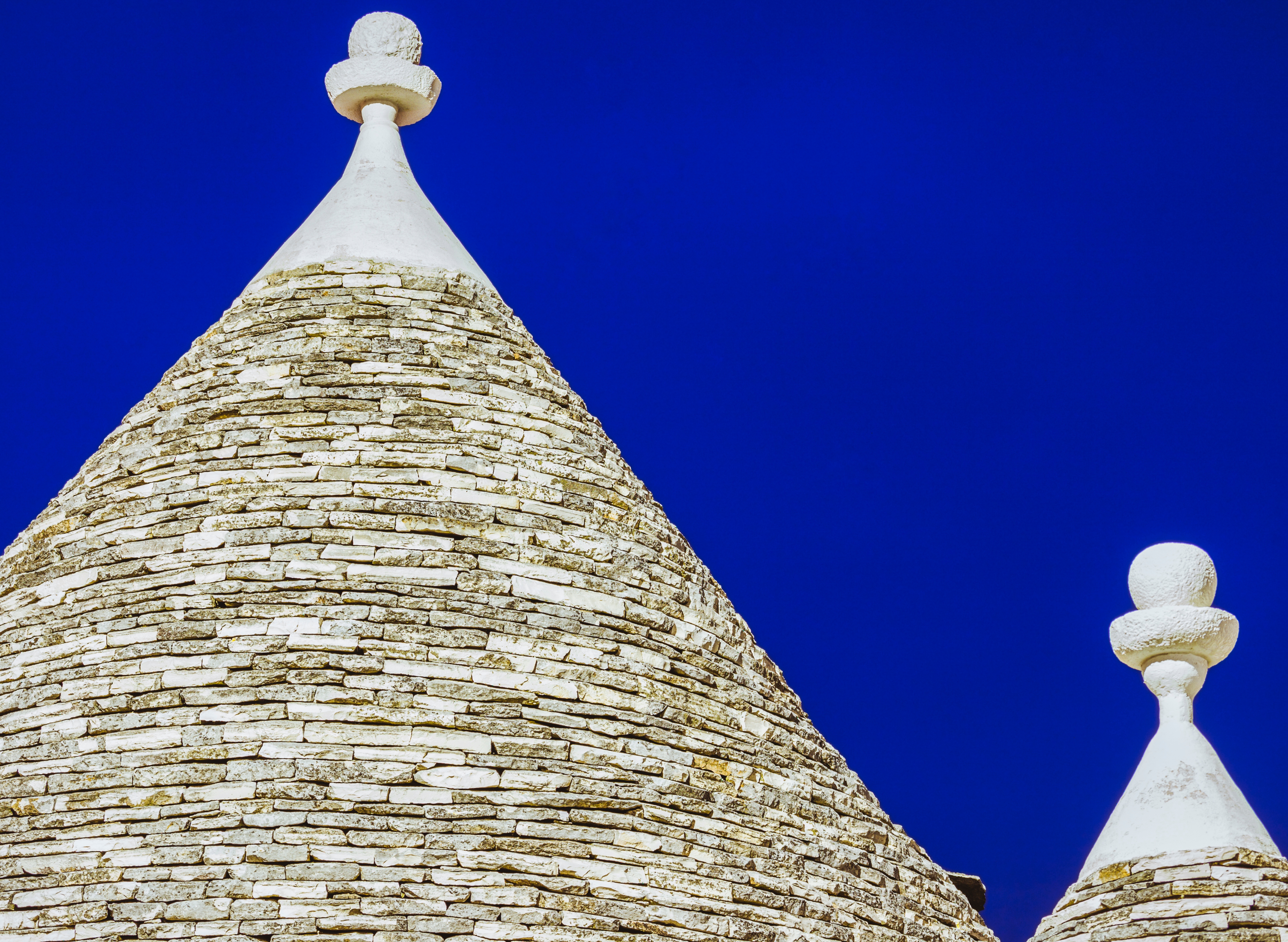 Unikke trulli strukturer med koniske kalkstenstage under blå himmel i Alberobello, Italien