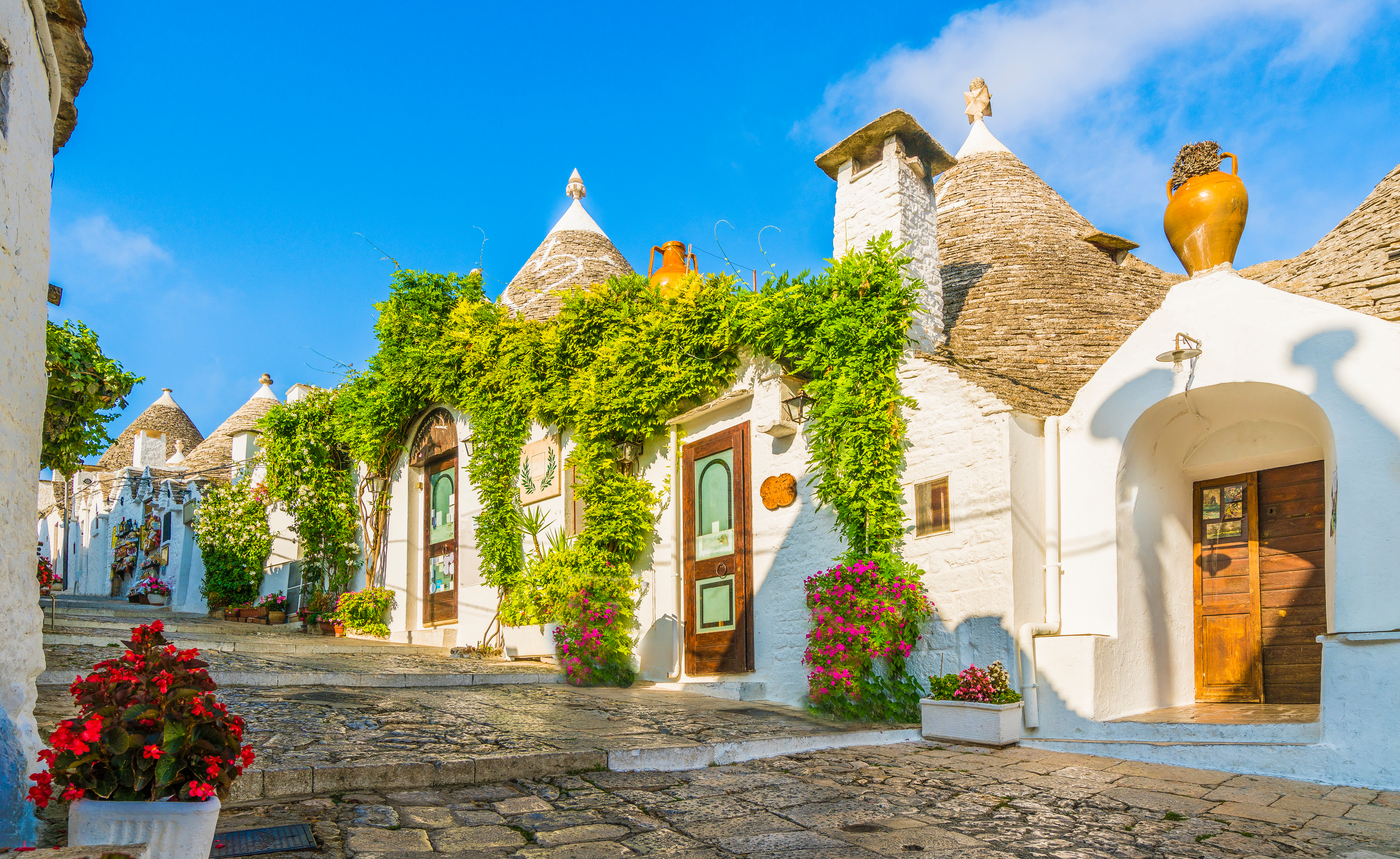 Charmerende gade med de berømte Trulli-huse i Alberobello i Puglia-regionen, med deres karakteristiske runde form og kegleformede tage, der repræsenterer en unik byggestil på UNESCOs verdensarvsliste