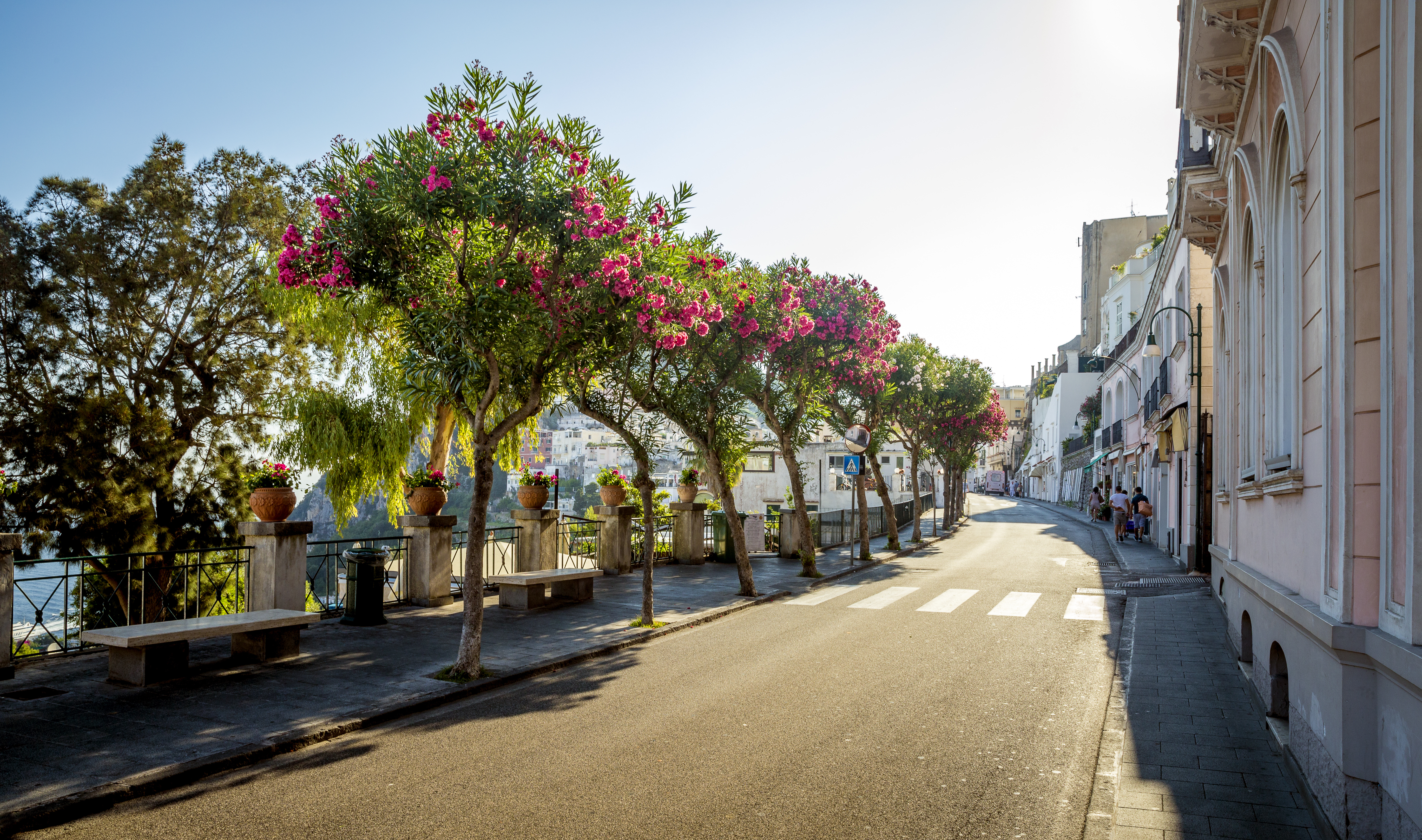 Idyllisk italiensk kystby med blomstrende gader og blå himmel - perfekt feriemål