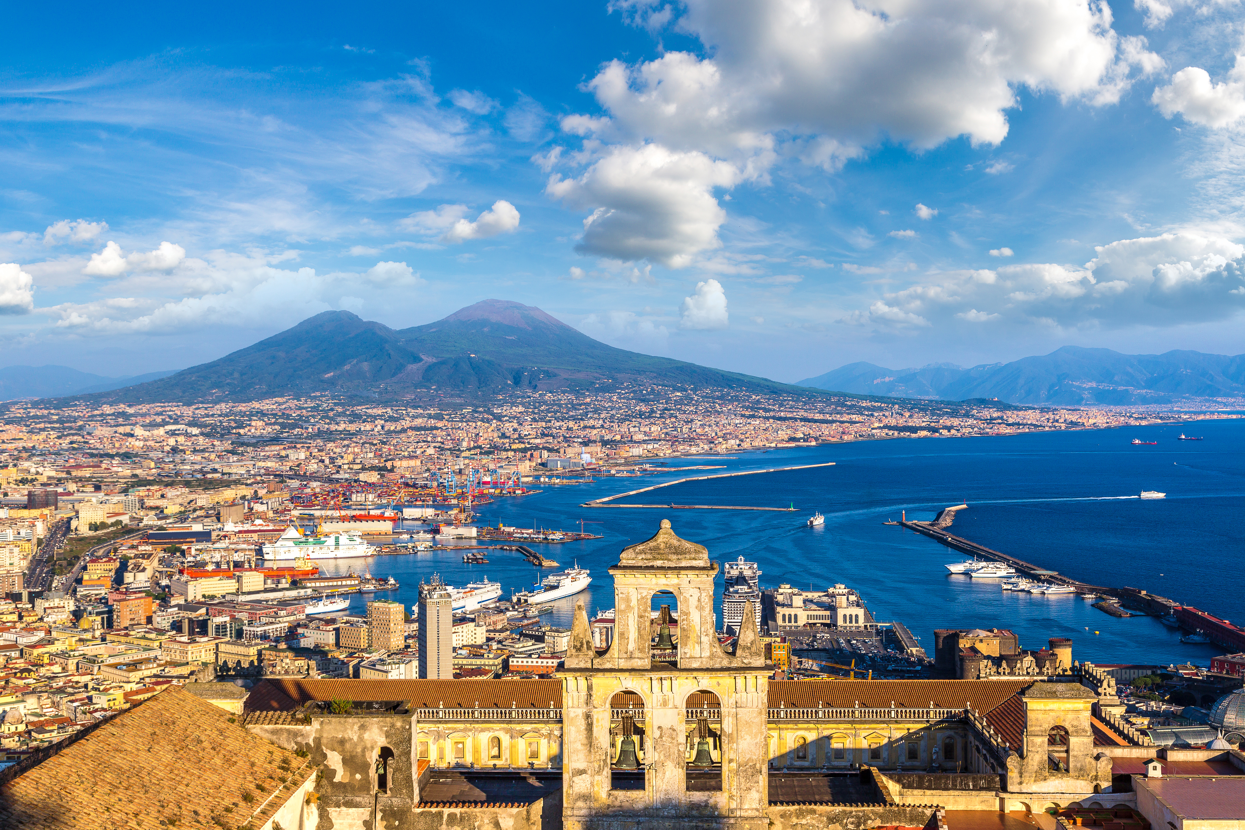 Italiensk kystby Napoli med ikonisk Vesuvius vulkan og azurblaa hav