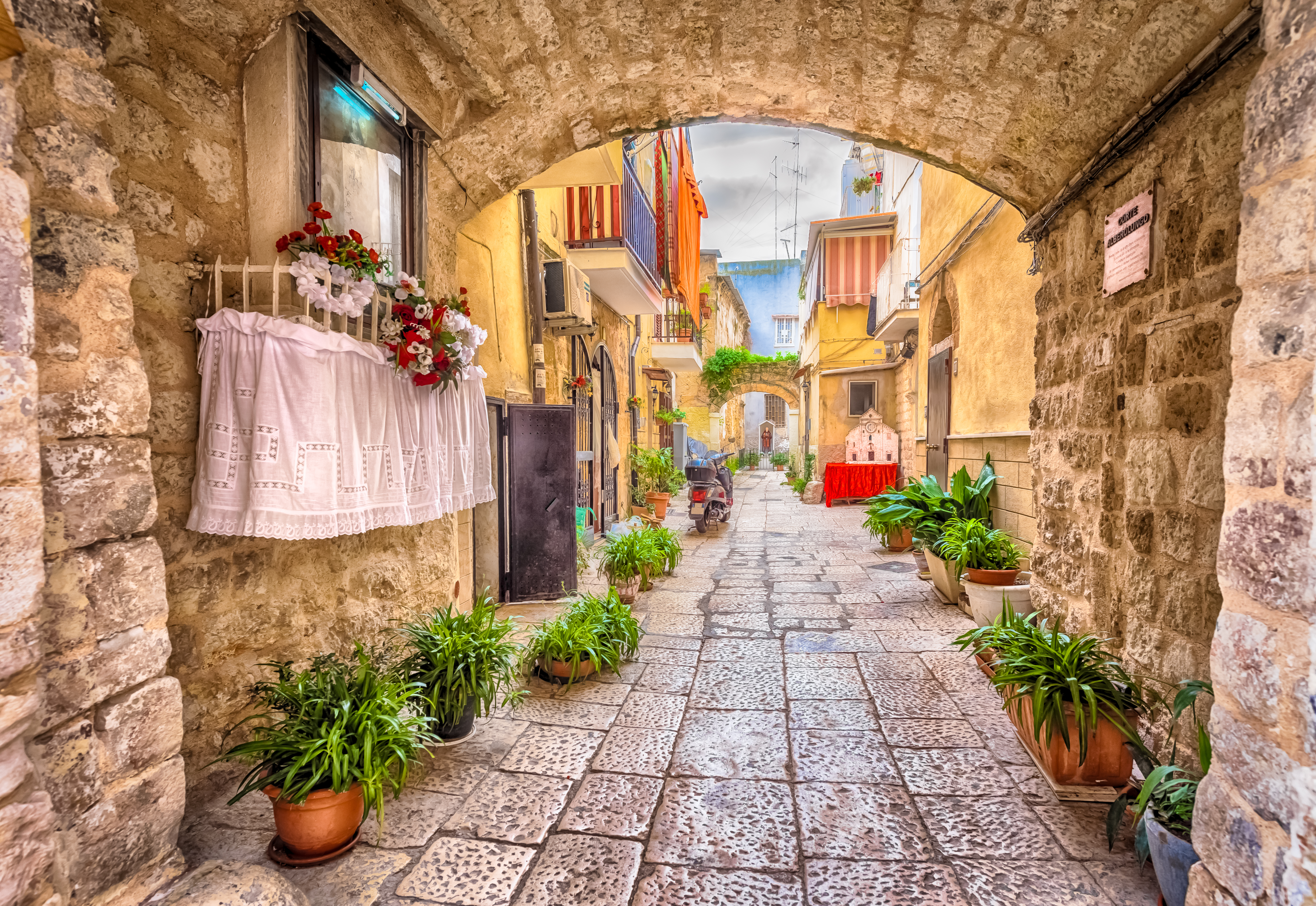 Stemningsfuld smal gade med karakteristisk hvid arkitektur i den historiske bydel af Bari i Puglia-regionen, Syditalien