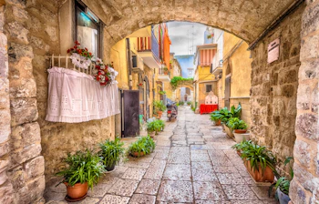 Stemningsfuld smal gade med karakteristisk hvid arkitektur i den historiske bydel af Bari i Puglia-regionen, Syditalien