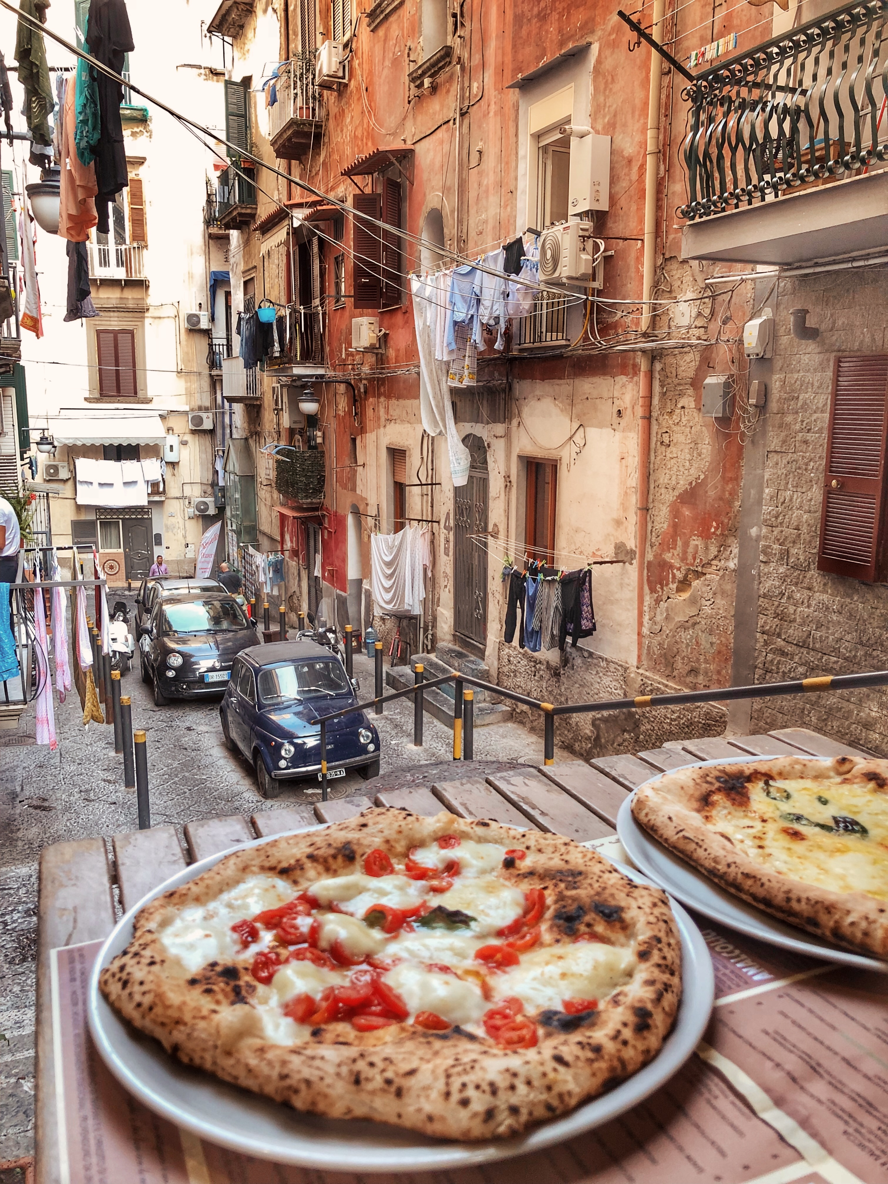 Autentisk pizza oplevelse på restaurant terrasse med udsigt til historiske bygninger i Napoli Italien