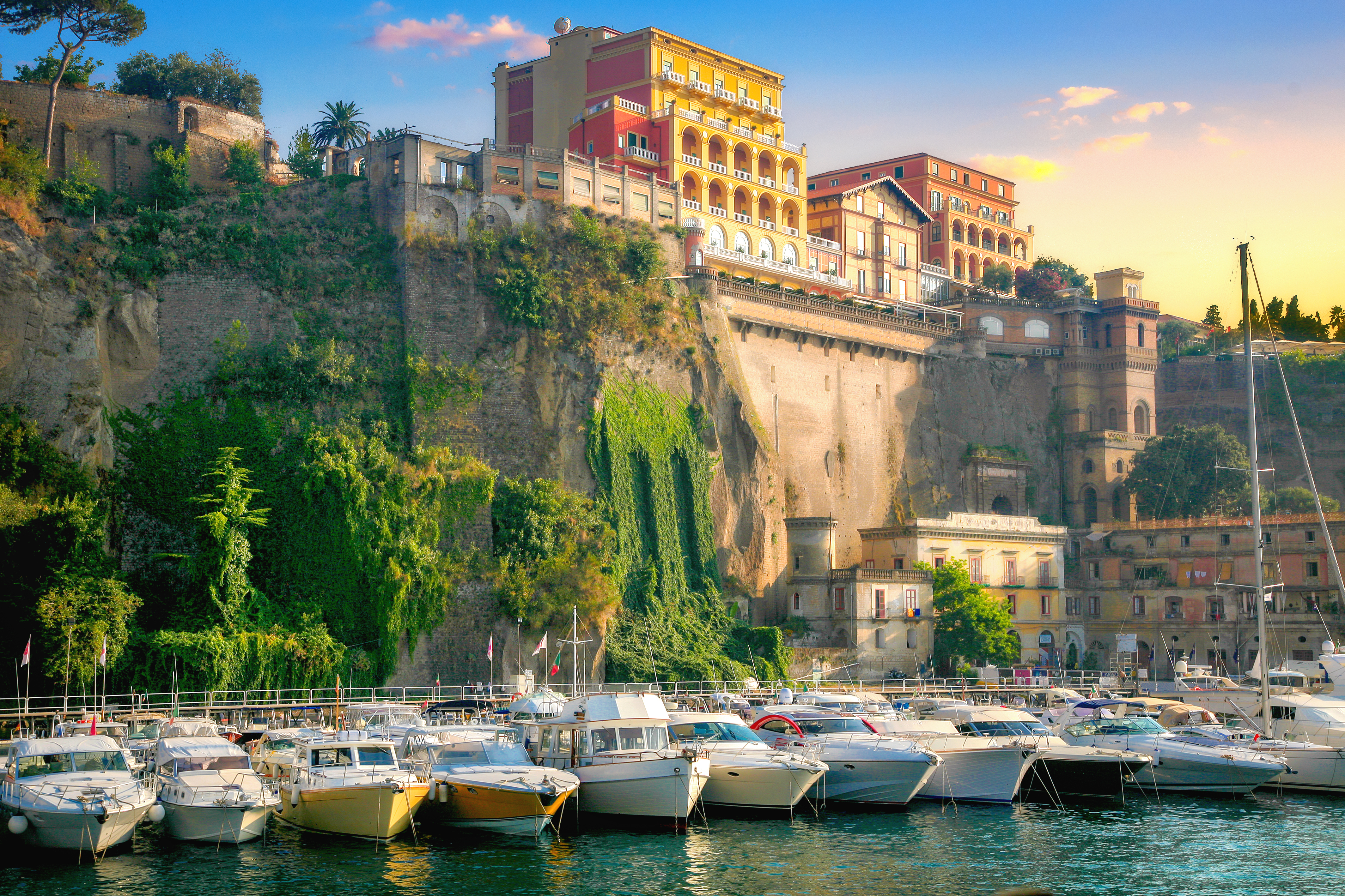 Charmerende lystbådehavn i Sorrento med farverige bygninger på høje klipper, Italien