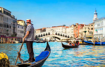 Autentisk gondoltur med erfaren gondolier forbi den berømte Rialto-bro i Venedig