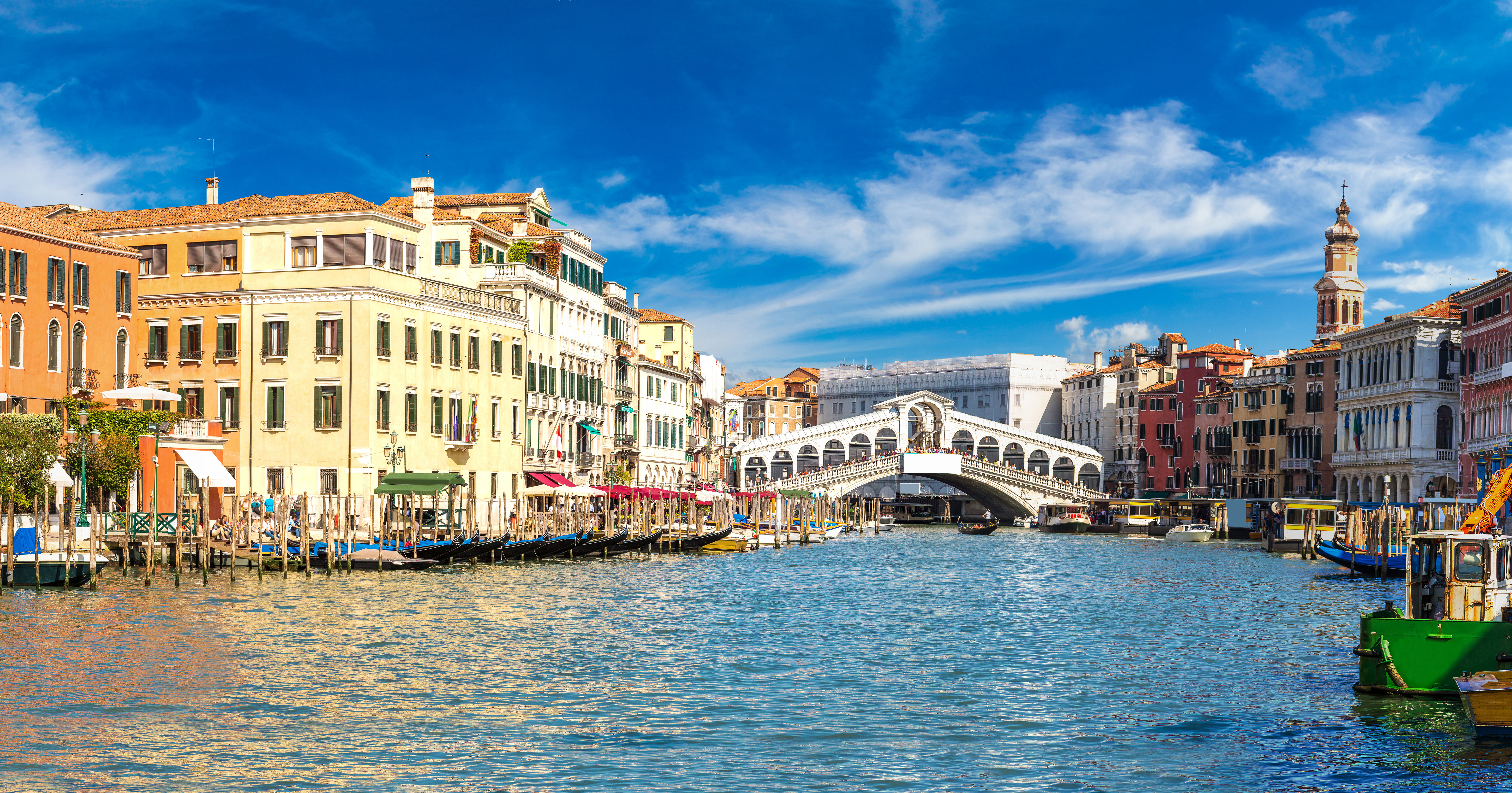 Udsigt over det romantiske Venedig med Canal Grande, Rialto-broen og historiske paladser langs bredden på en solskinsdag i Italien