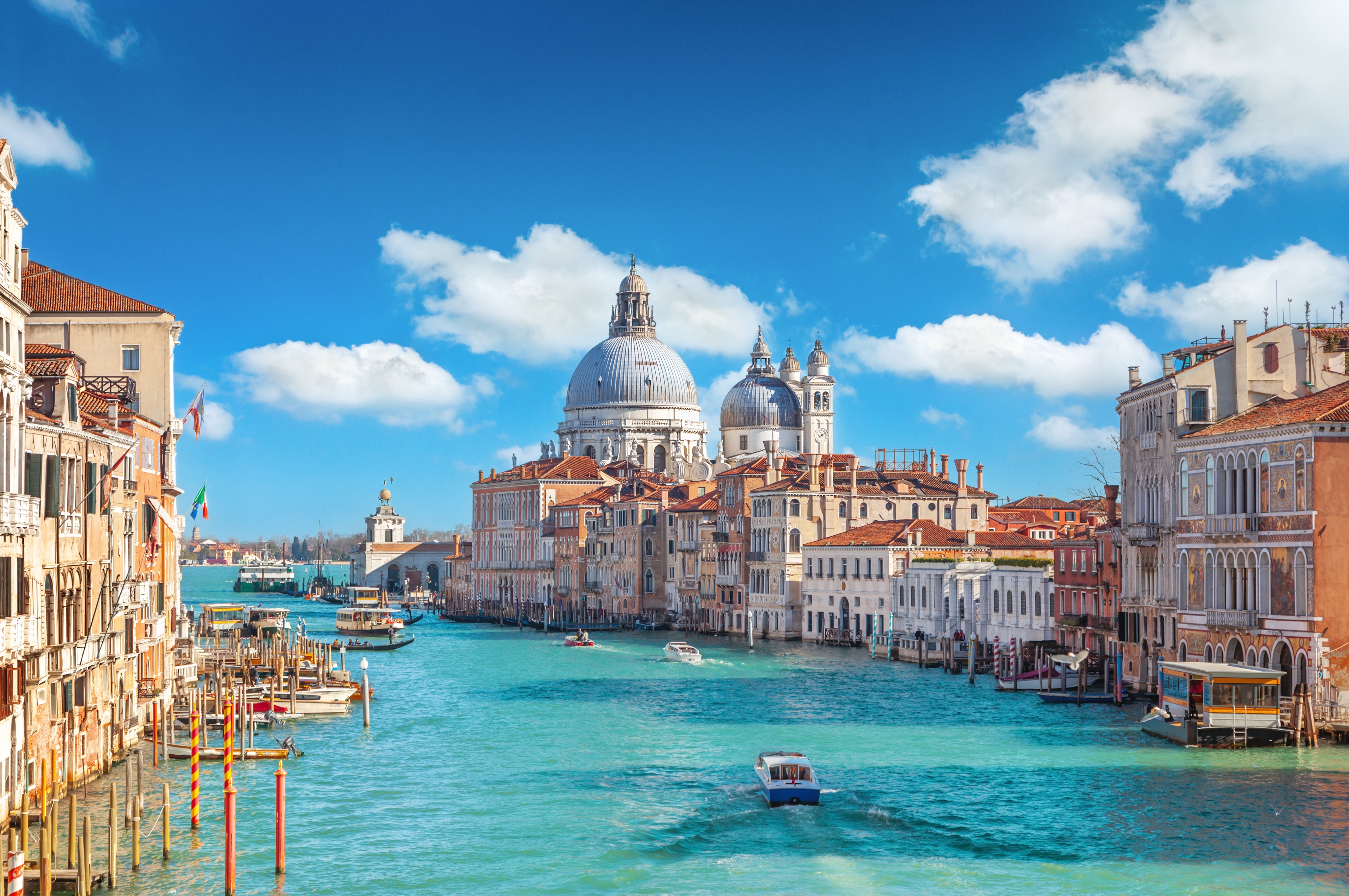 Venedigs beroemte Grand Canal med barokkirke og traditionelle baade under blaa himmel