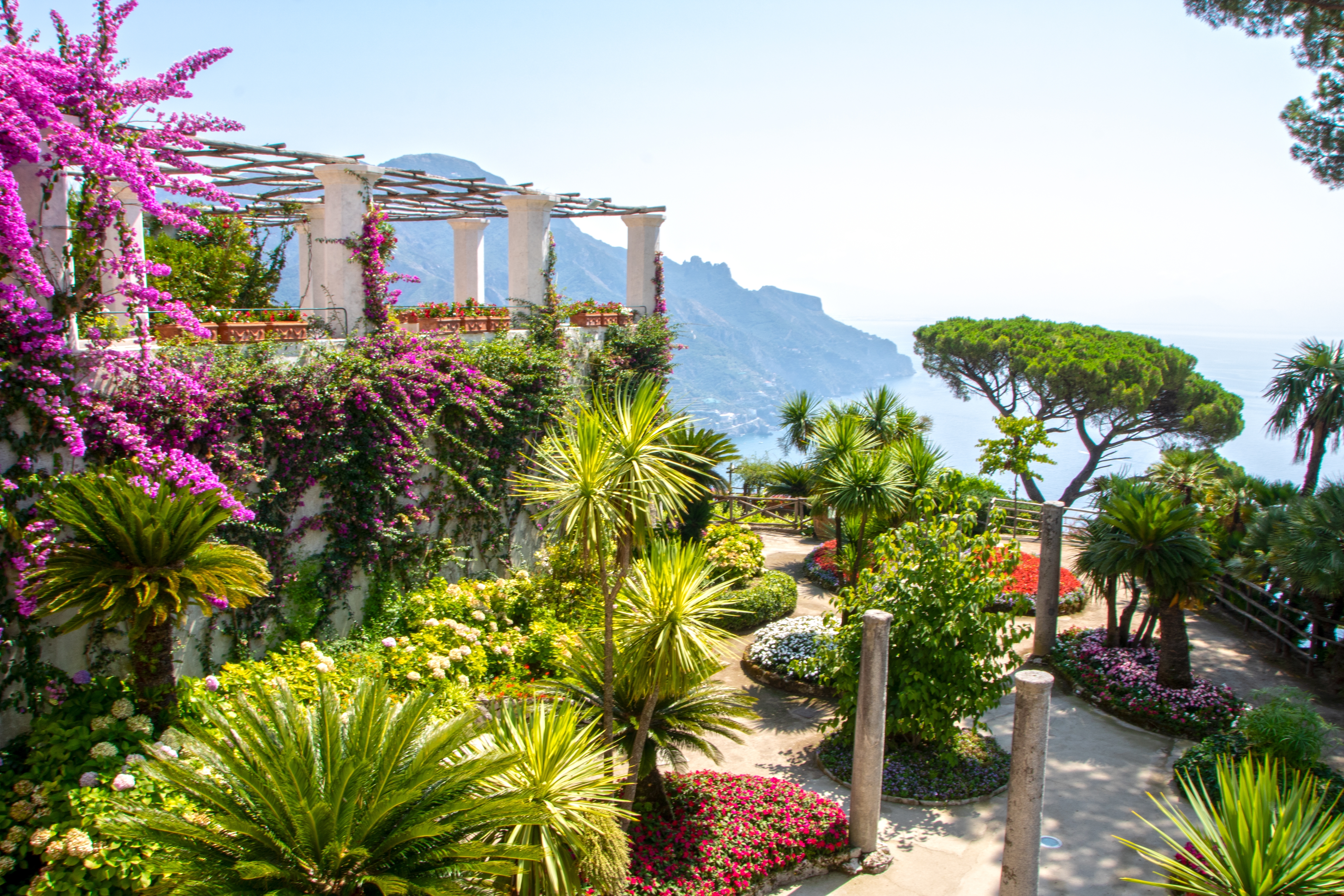Italiensk villa med botanisk have, palmer og bougainvillea blomster med havudsigt