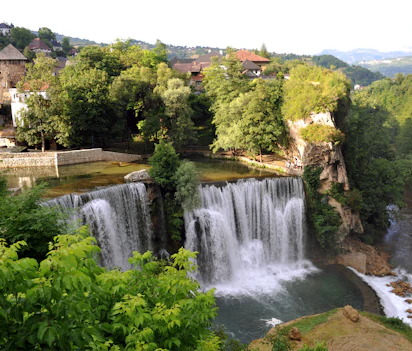 Majestætisk vandfald ved Jajce med middelalder fæstning og historiske mure i Bosnien