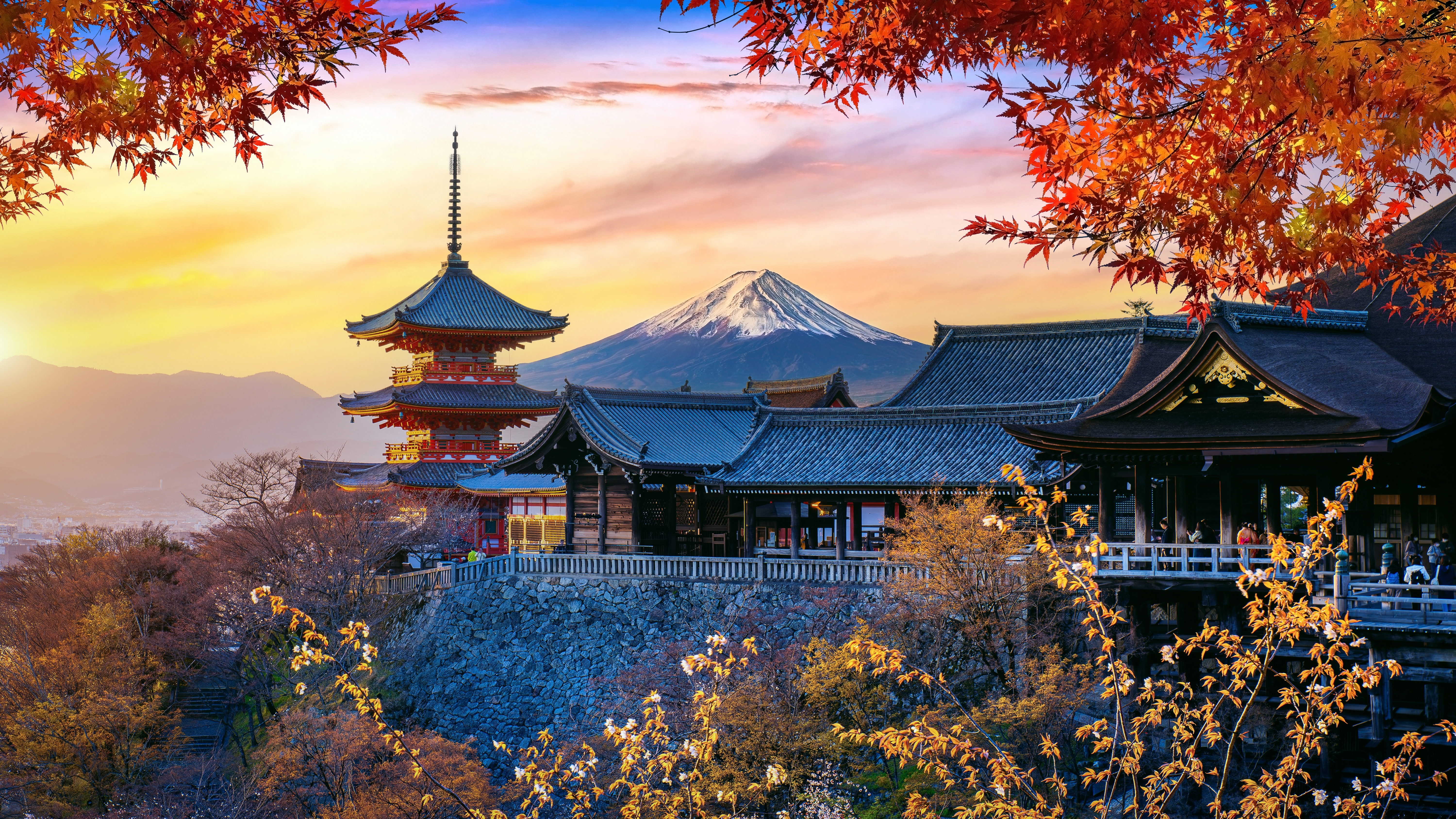 Fascinerende japansk efterårssceneri med den berømte røde momiji-løv og historisk pagode i Kyoto badet i varmt solnedgangslys