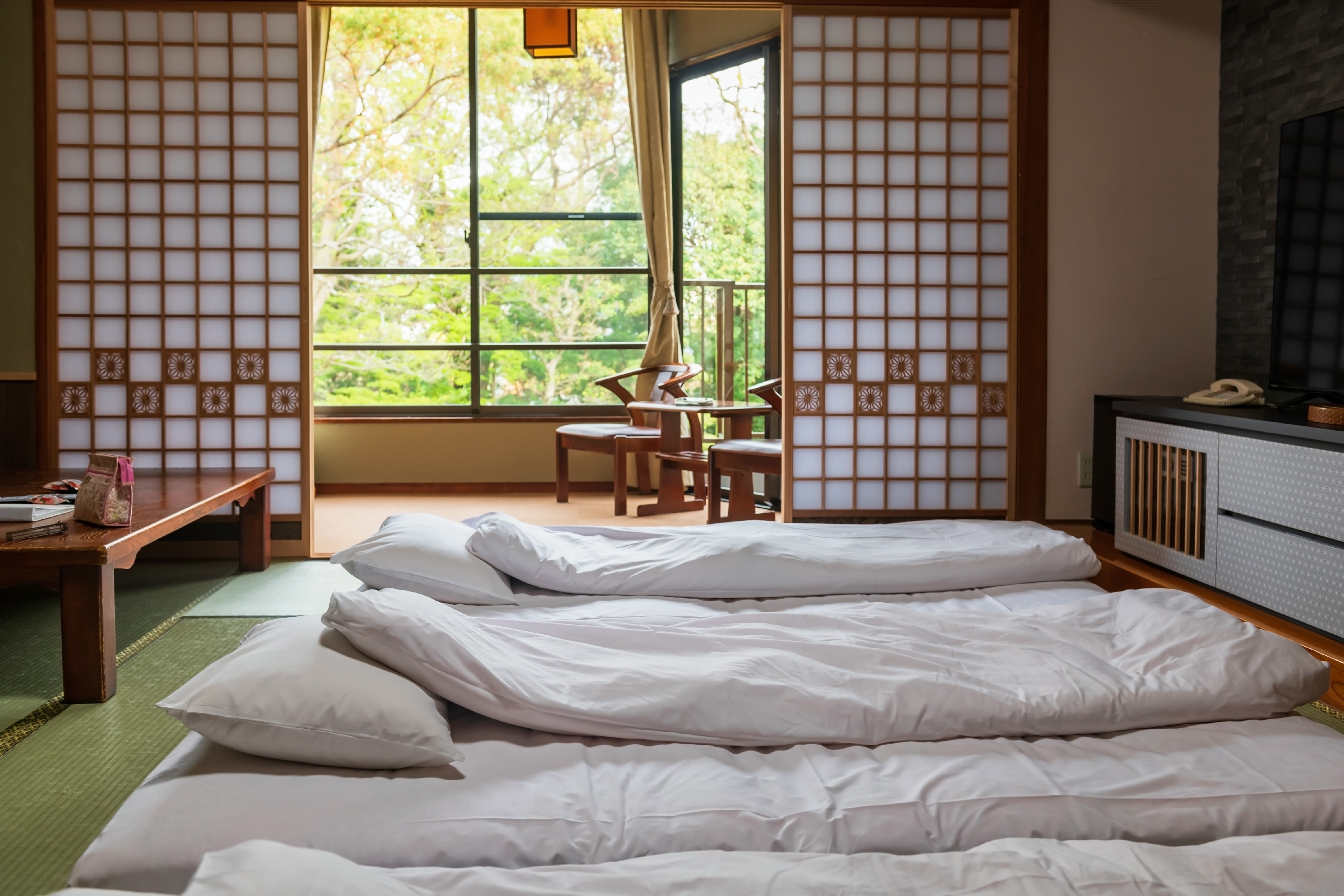 Kulturel japansk overnatning på ryokan med tatami gulv, futon senge og traditionelle shoji døre