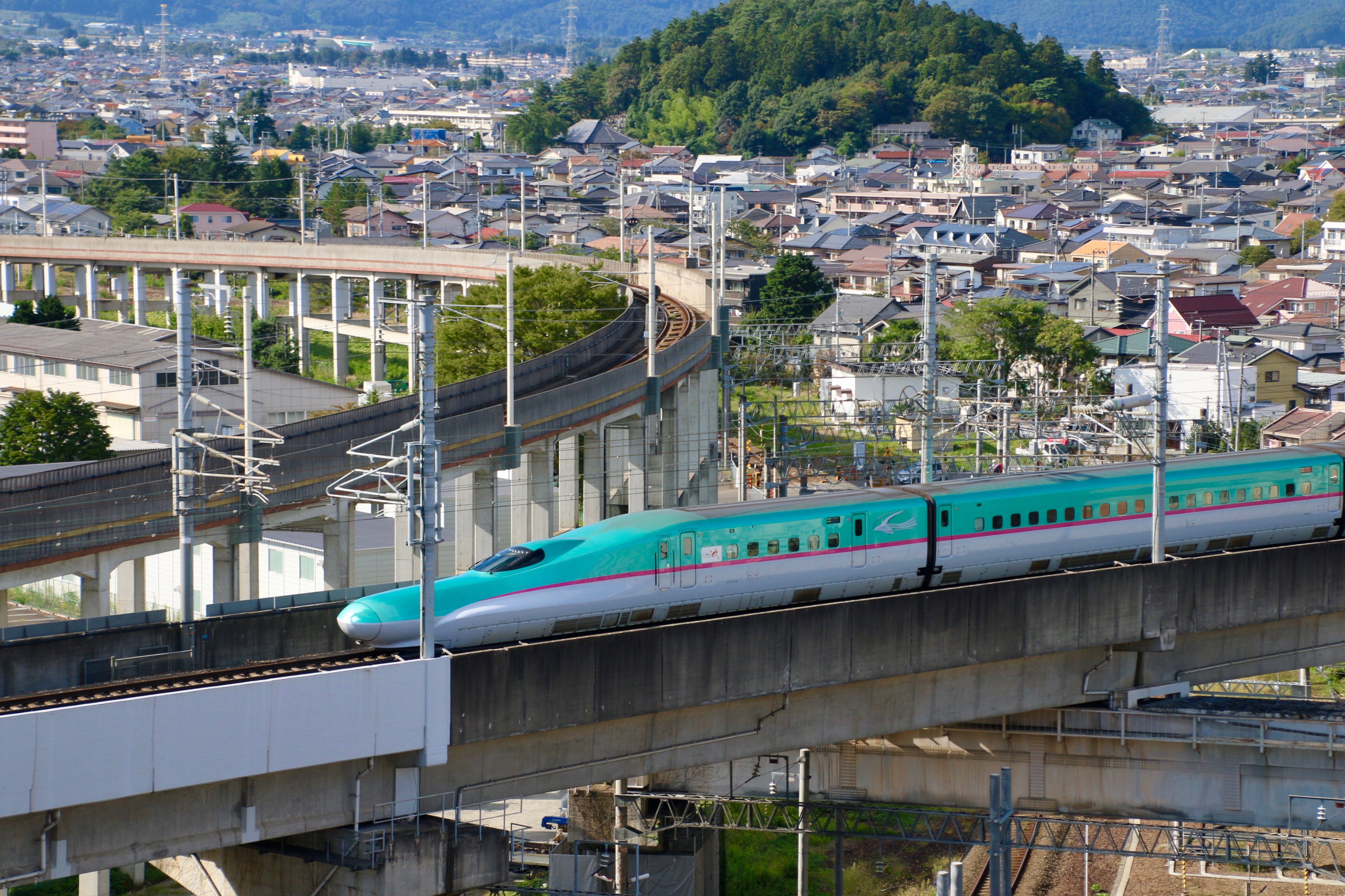 Shinkansen højhastighedstog passerer gennem Fukushima med traditionelle japanske huse
