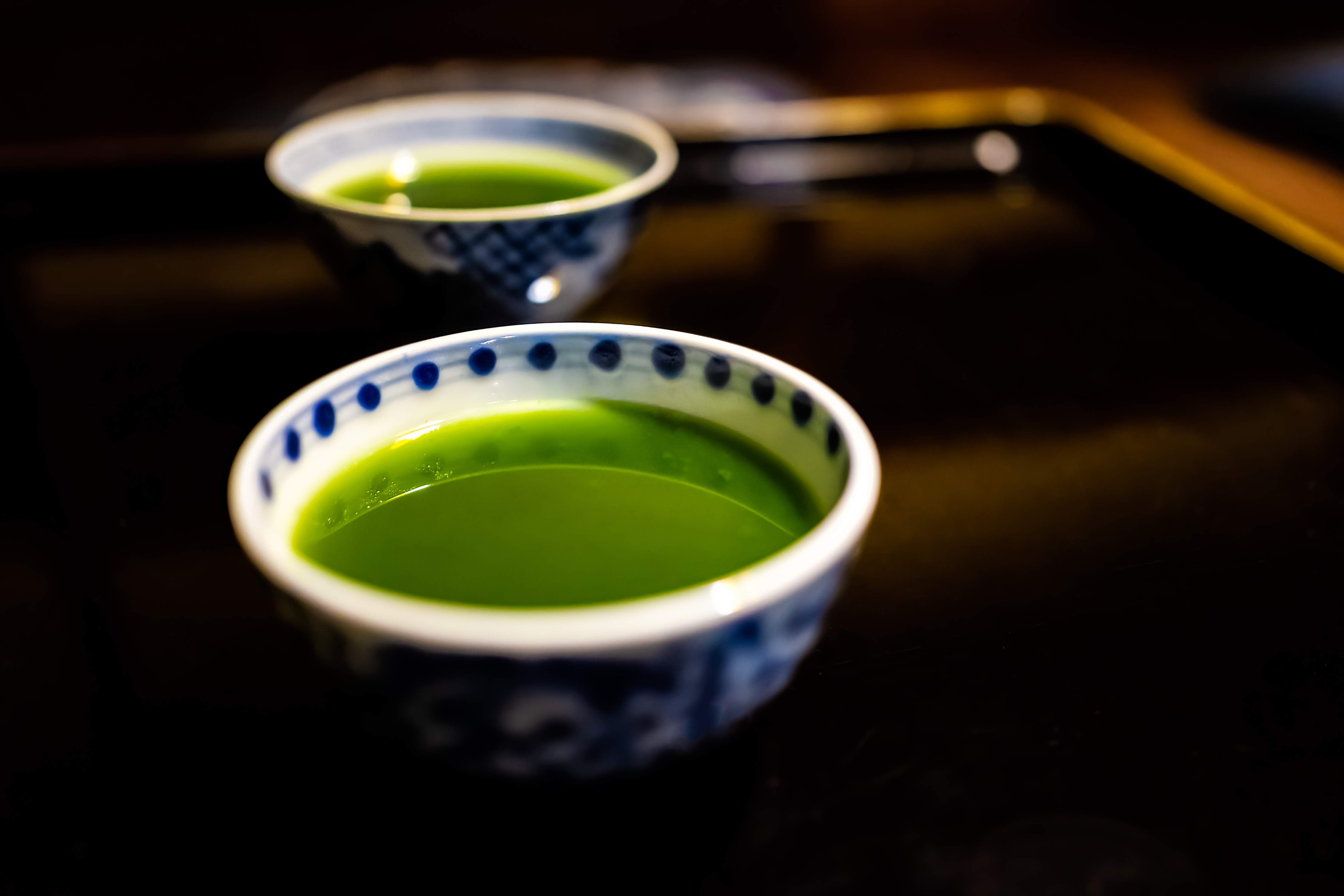 Japansk te ritual med blå keramik skåle og frisk matcha te