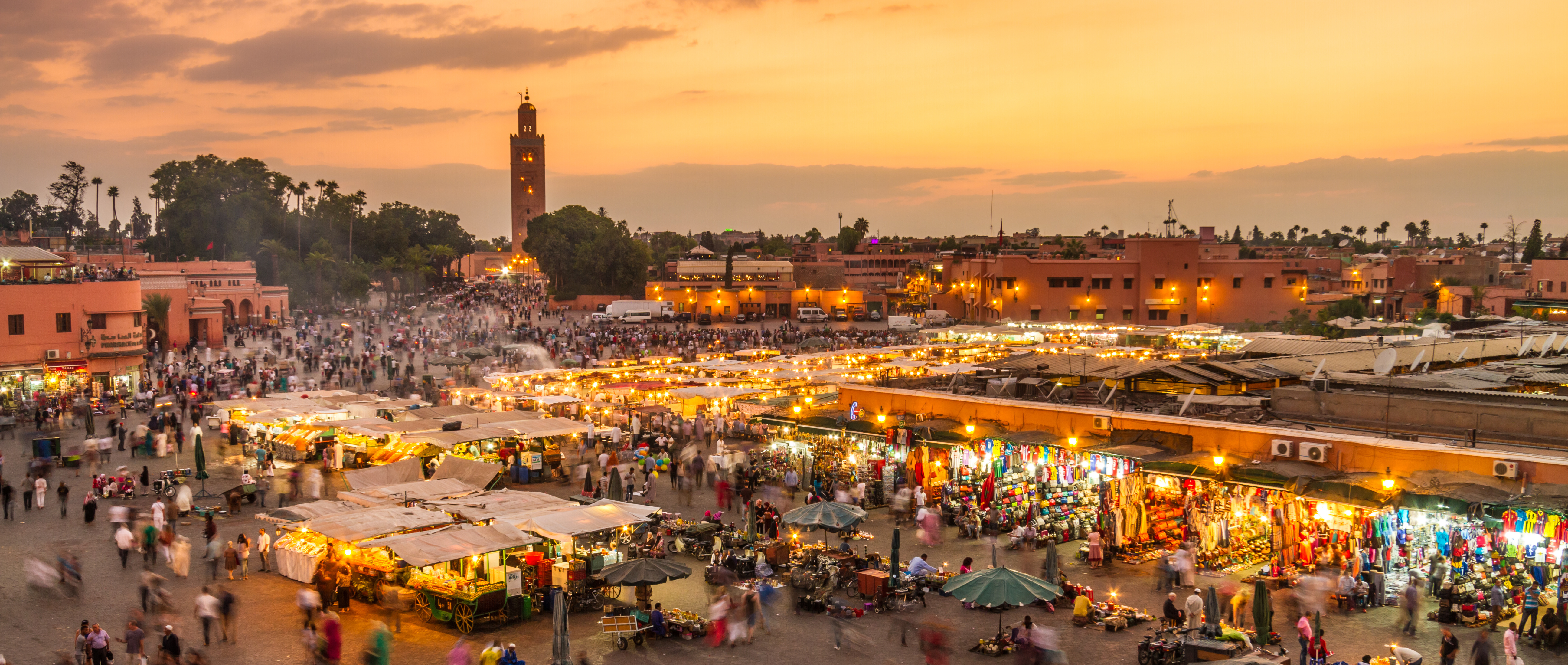 Luftudsigt over det travle Jemaa el-Fna-marked i Marrakech ved solnedgang med hundredvis af markedsboder og turister på den UNESCO-listede plads