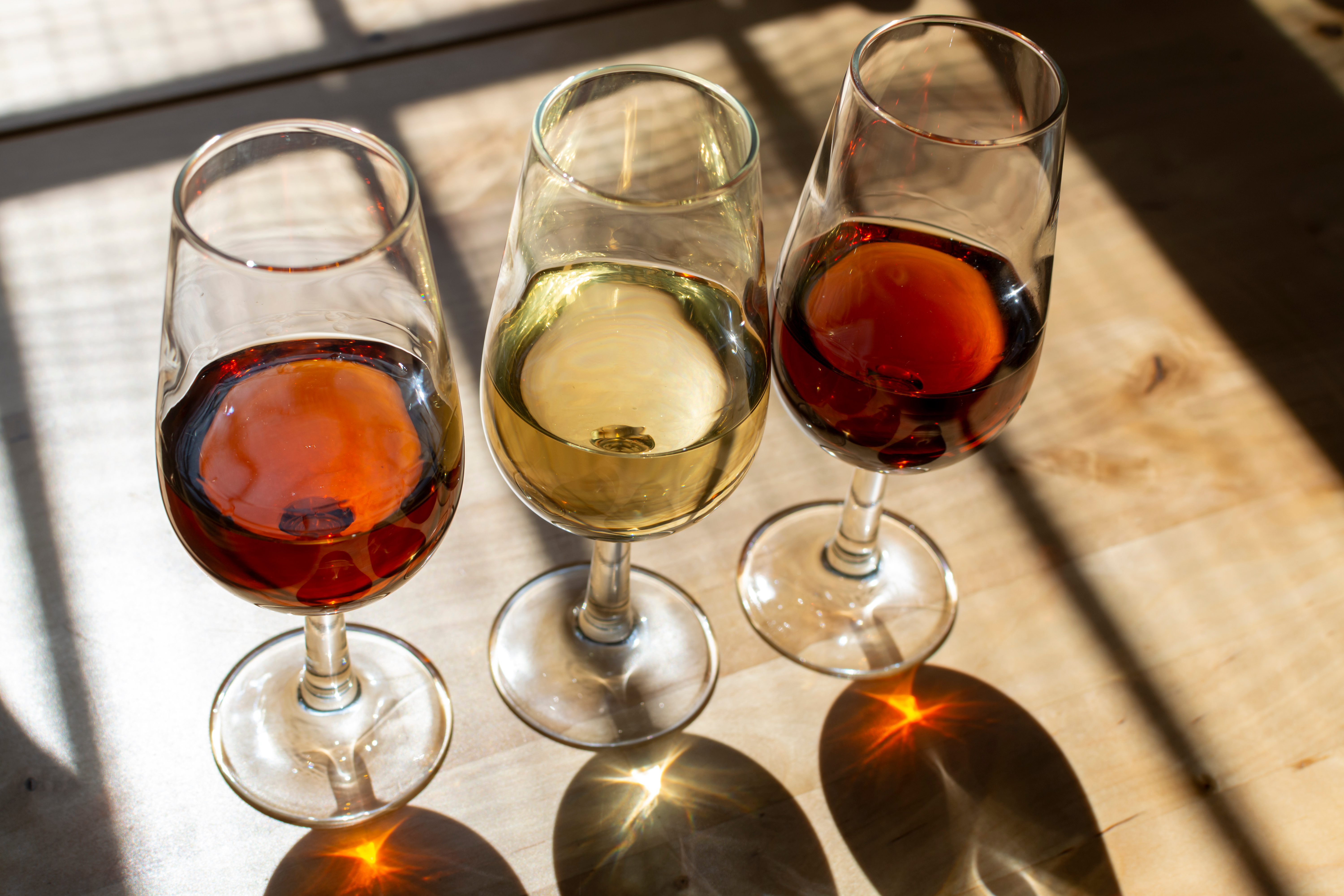 Tre glas sherry vin i varm sollys under vinsmagning i spansk bodega