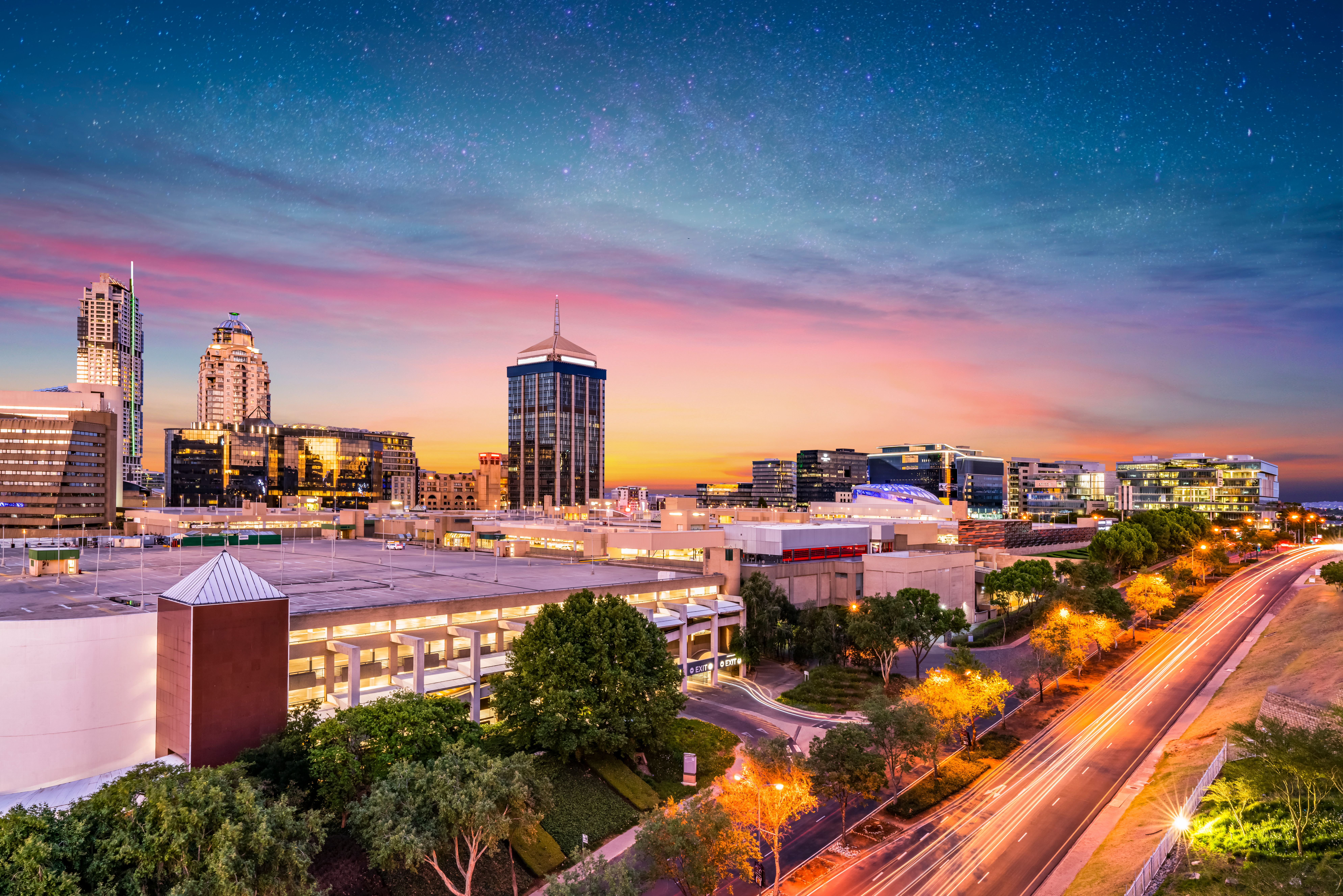 Betagende udsigt over Sandtons moderne arkitektur og bylandskab i aftenlys - et populært rejsemål i Johannesburg, Sydafrika