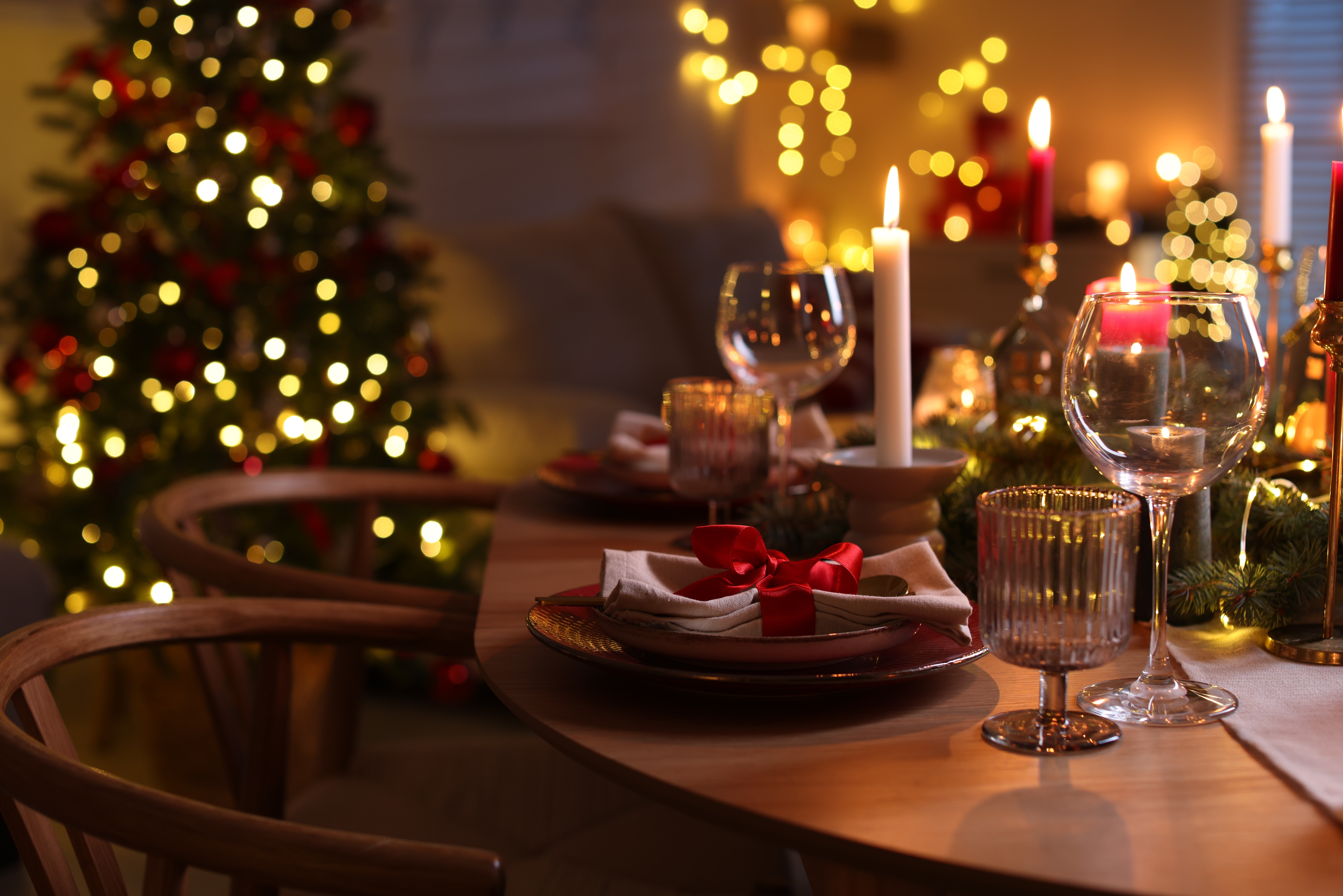 Smukt dækket julebord med levende lys og juletræ – perfekt til julerejen
