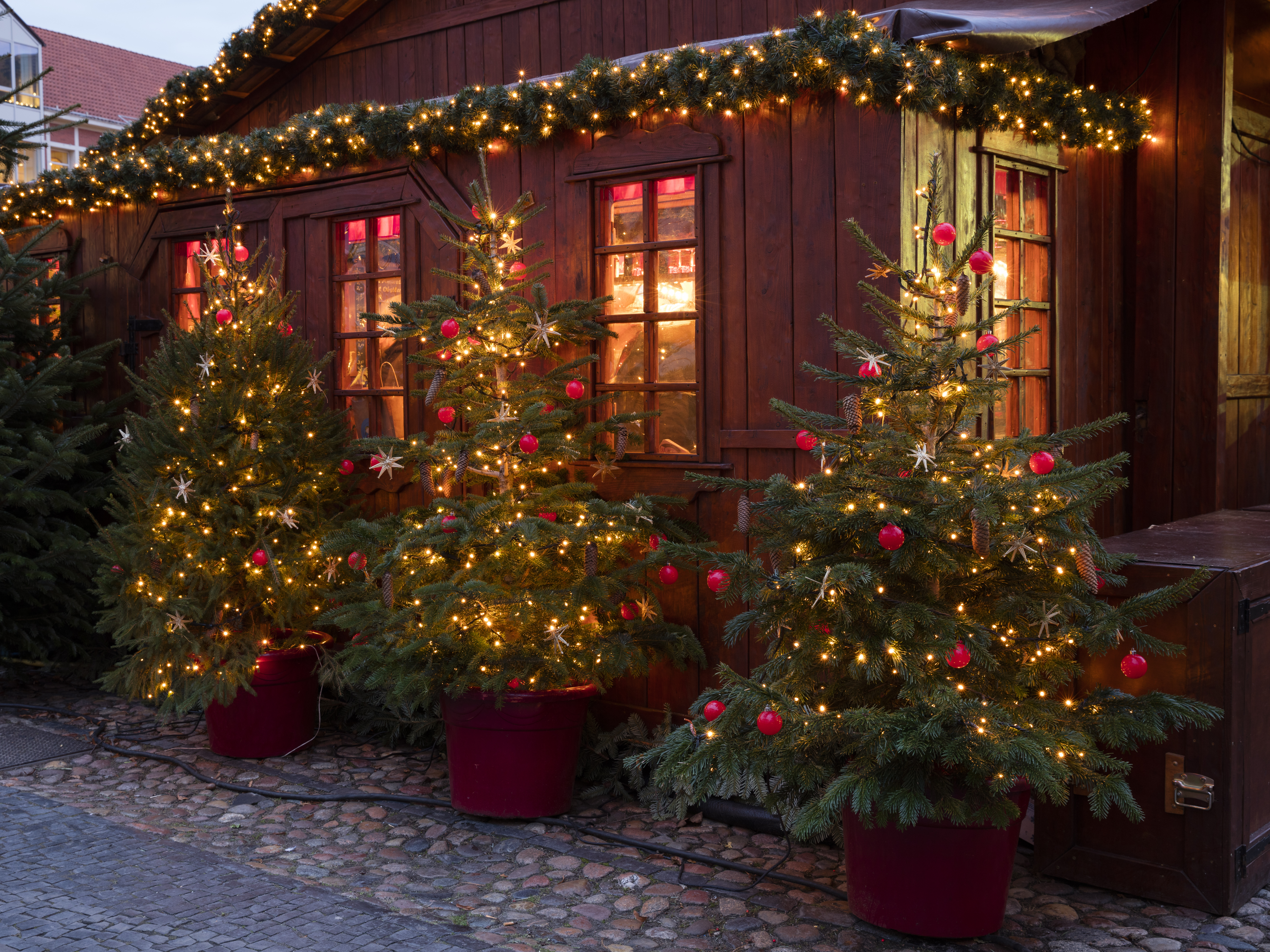 Charmerende julebod i træ med lysende juledekoration og træer