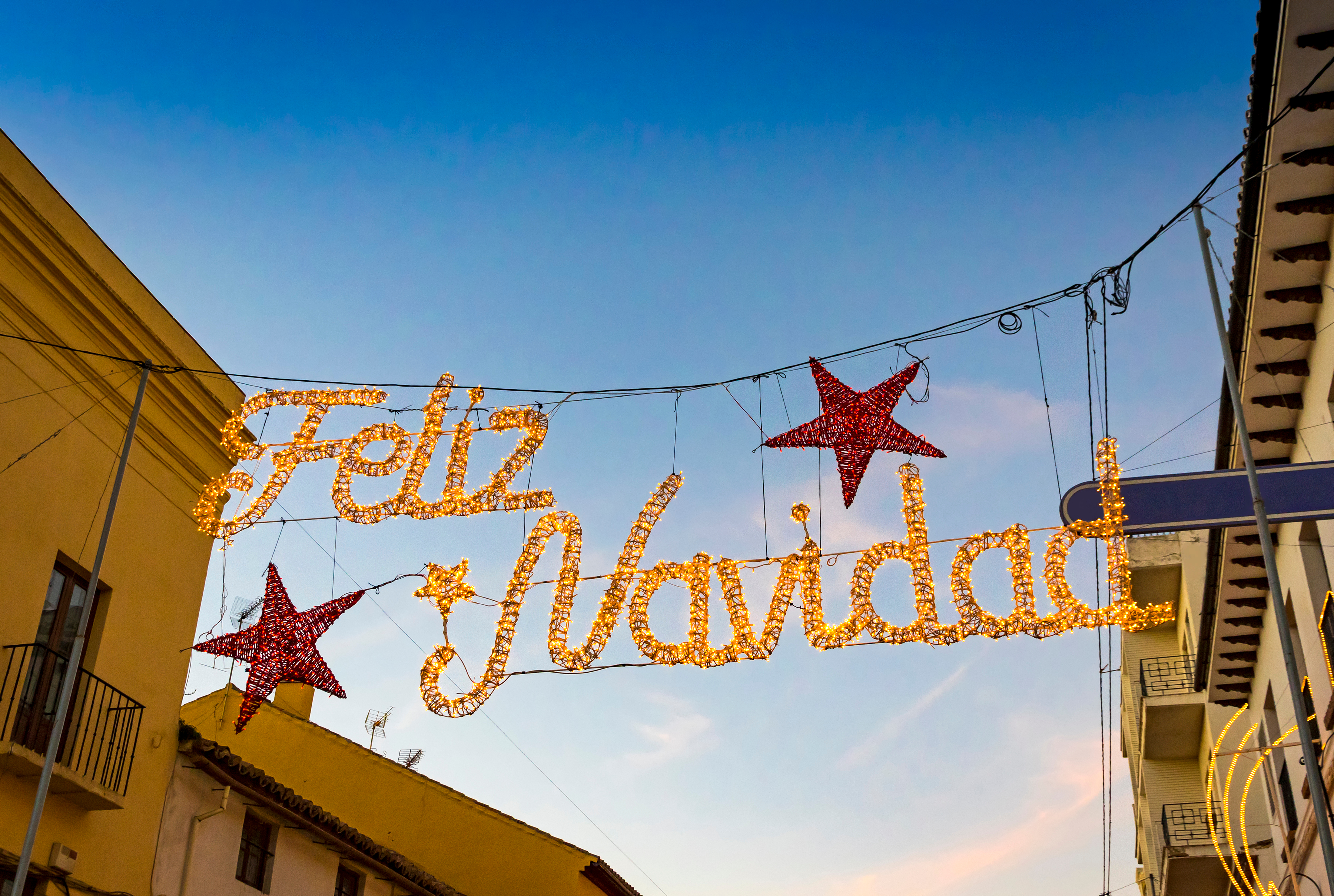 Glødende Feliz Navidad julelys hænger over gaden i Ronda by, Malaga provinsen, Andalusien i Spanien
