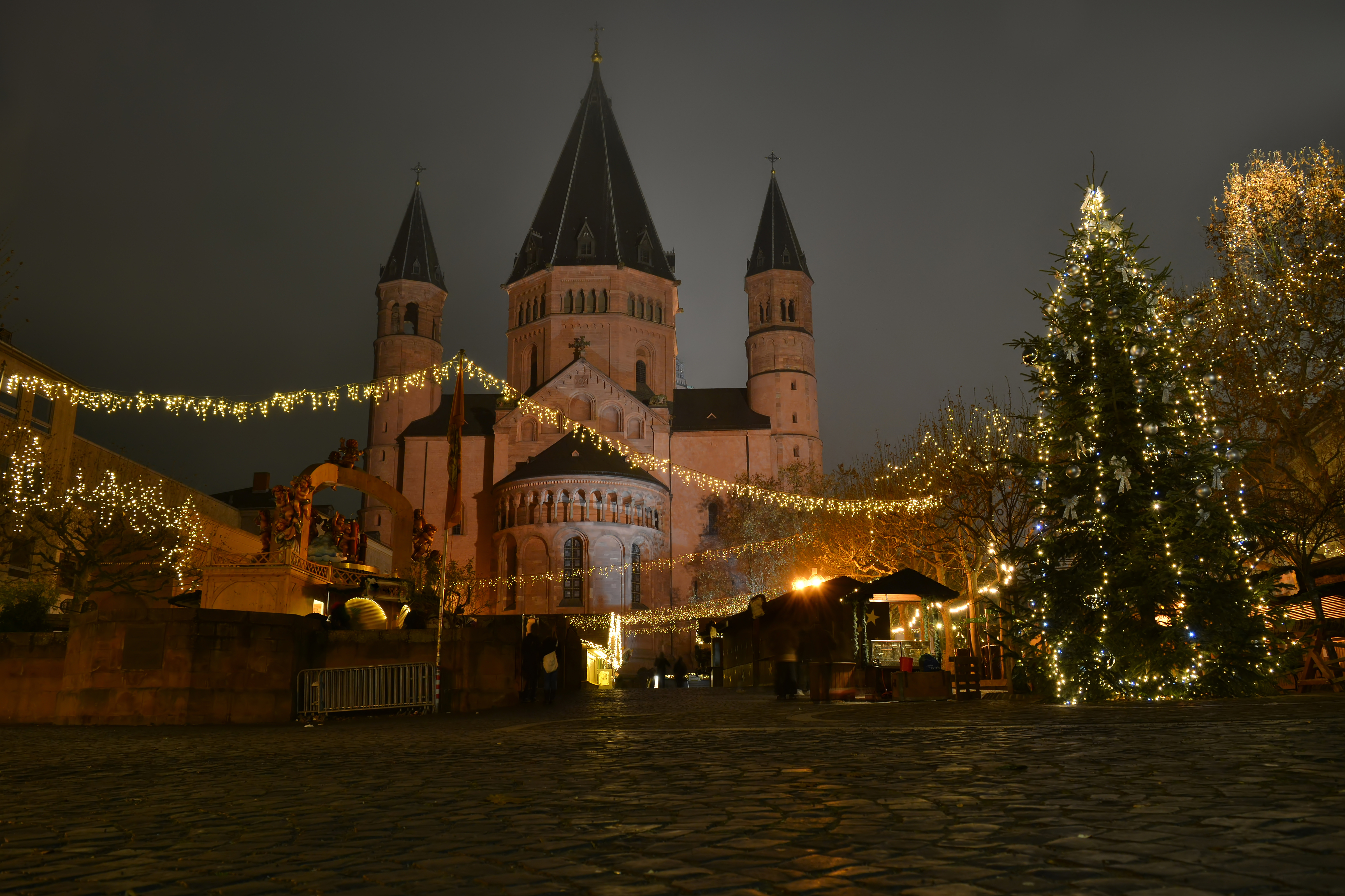 Romantisk julemarked ved Mainz Domkirke med juletræer og lys i Tyskland