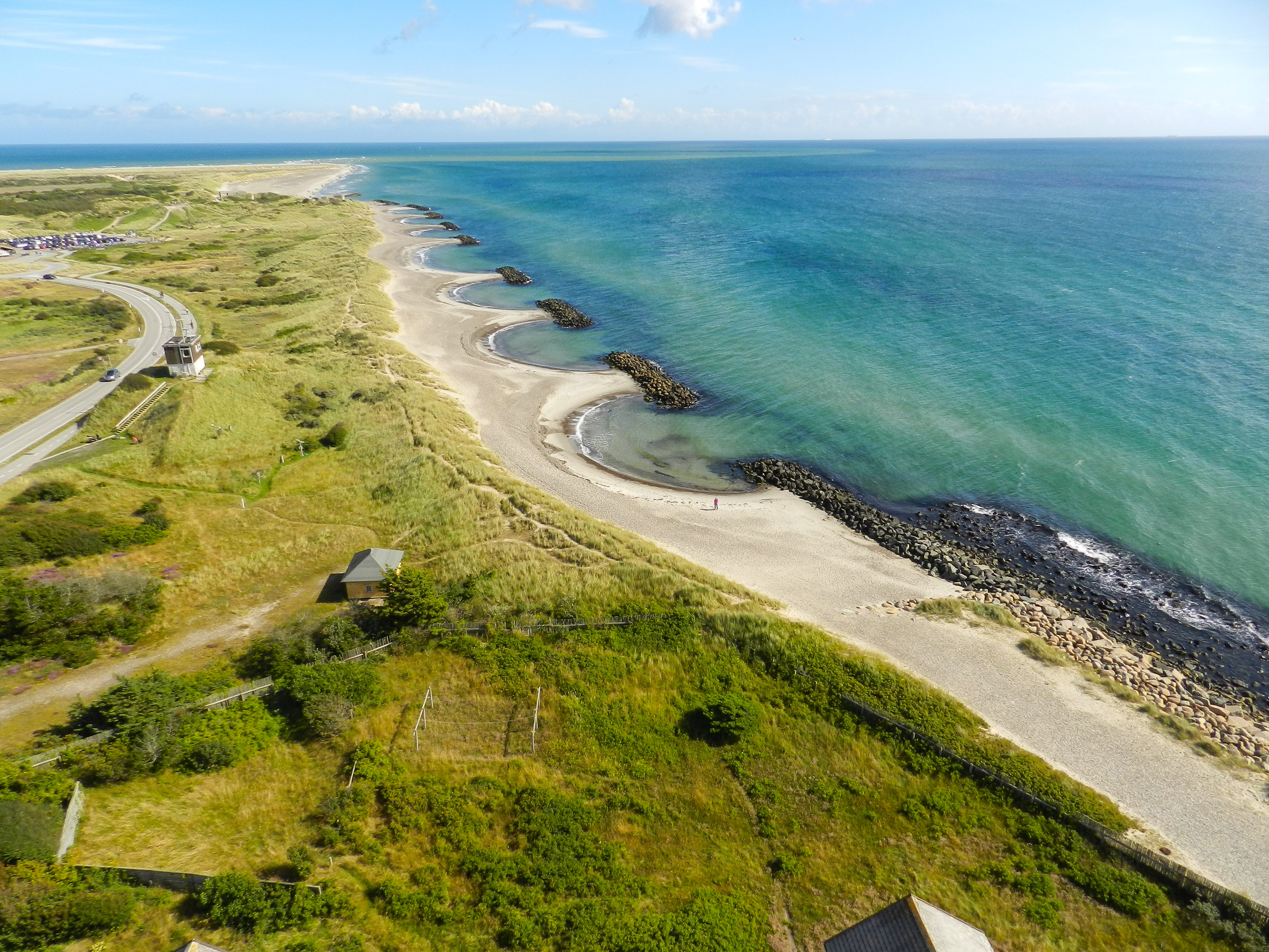 Luftoptagelse af jysk vestkyst med turkisblåt hav og sandstrand