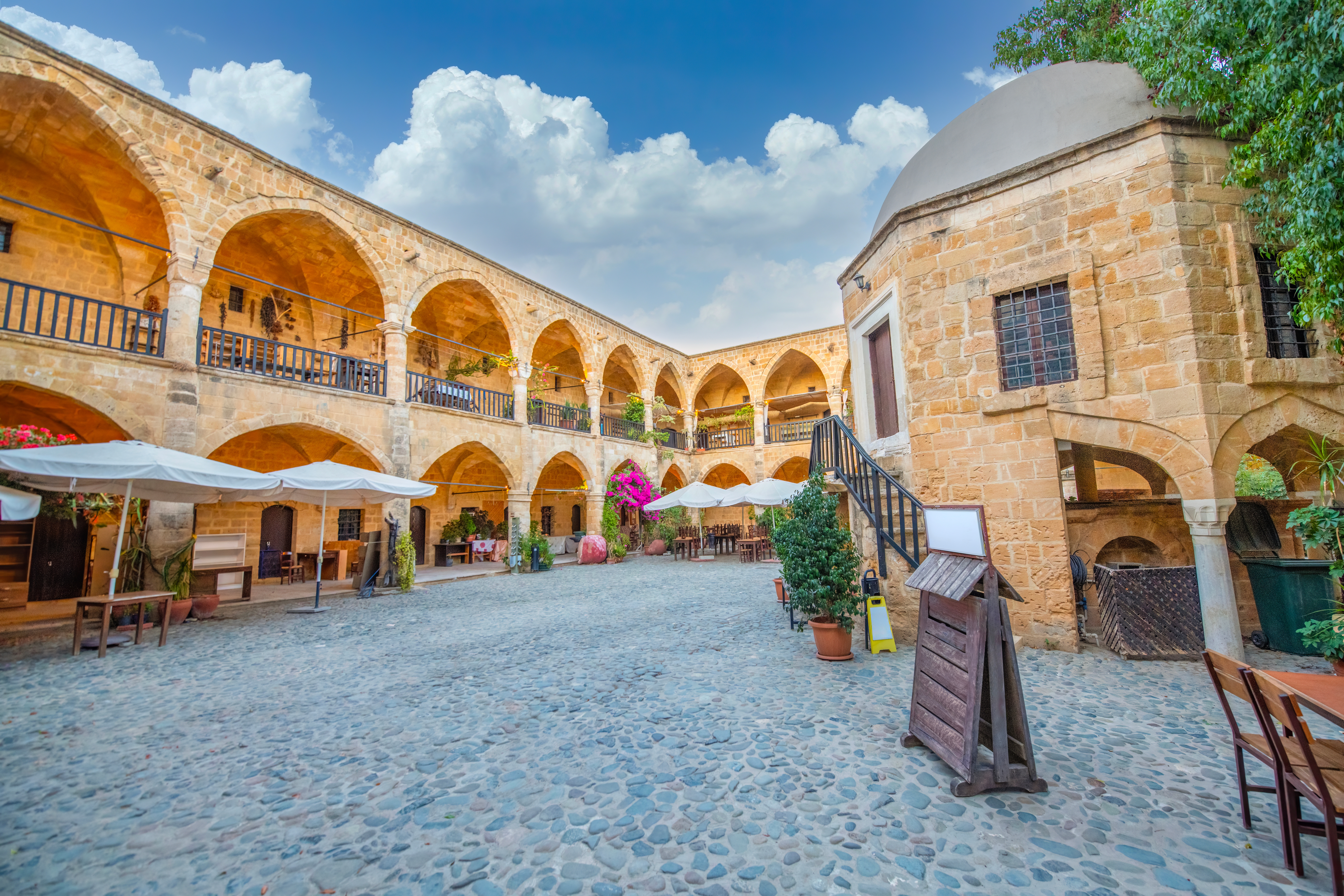 Historisk ottomansk karavanseri i Nicosia, Nordcypern, med gyldne stenbuer og charmerende brolagt gårdsplads