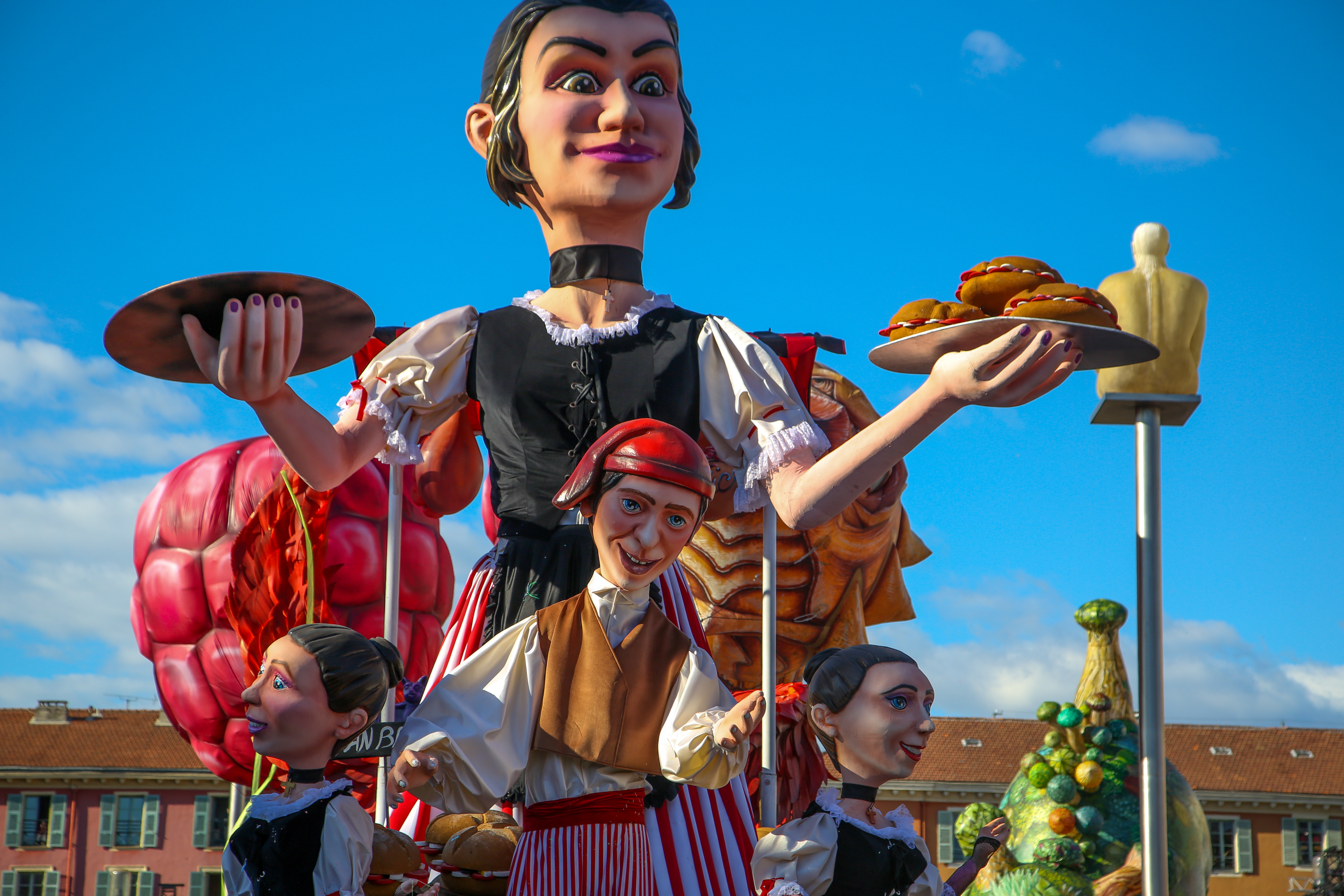 Kæmpe dekorative figurer i traditionelle dragter ved det farverige Nice Karneval i Sydfrankrig