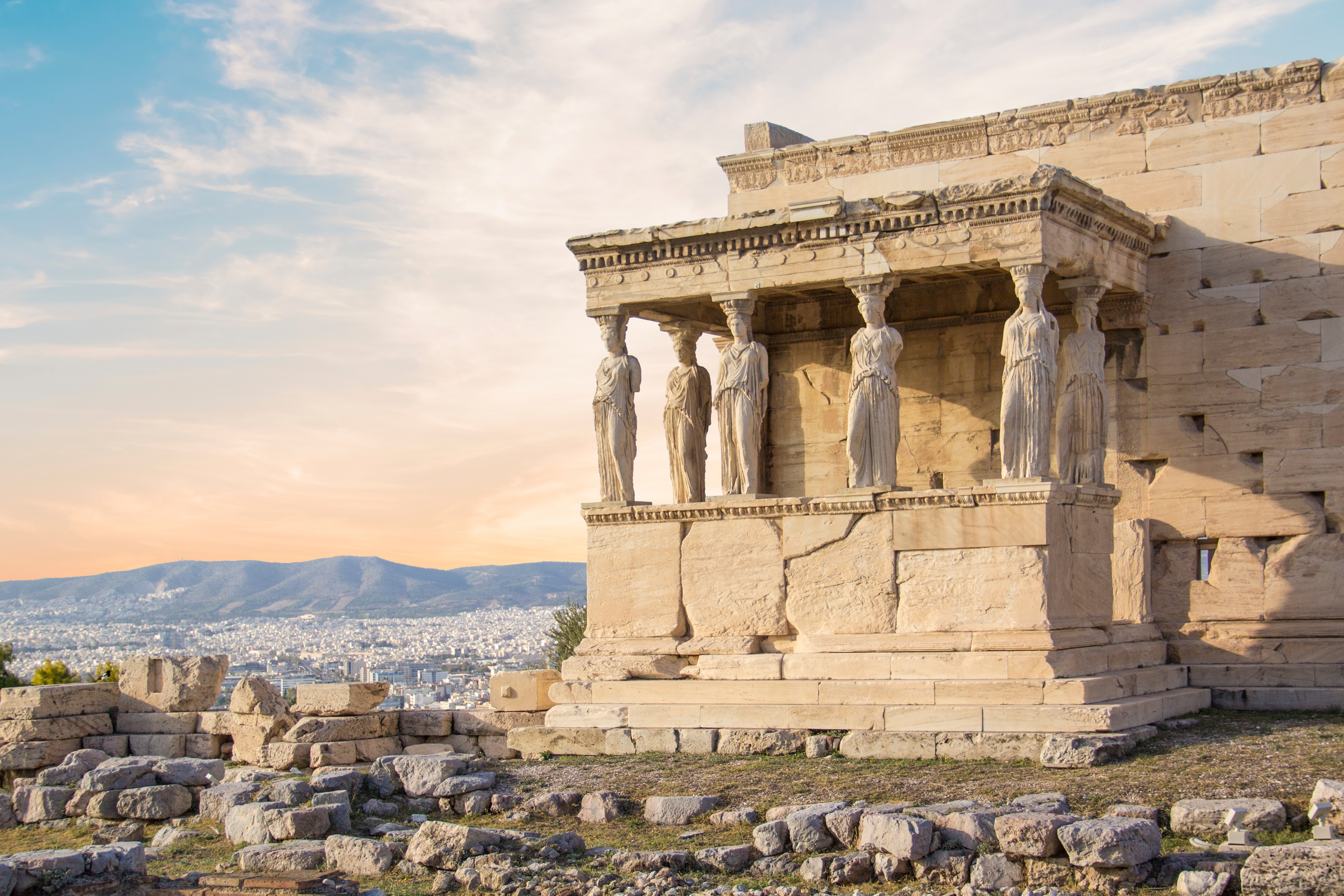 Antikt græsk Erechtheion-tempel med de ikoniske Karyatide-statuer på Akropolis i Athen med byudsigt og bjerge