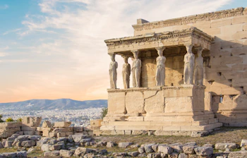 Antikt græsk Erechtheion-tempel med de ikoniske Karyatide-statuer på Akropolis i Athen med byudsigt og bjerge