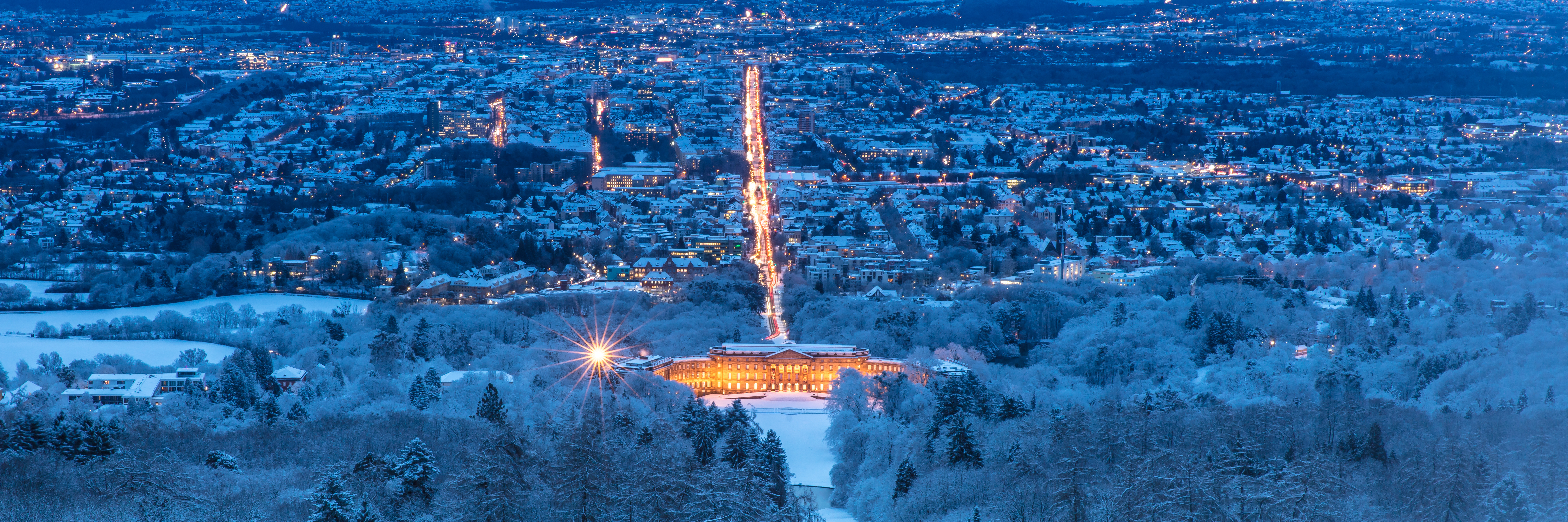 Panoramaudsigt over Kassel i Hessen om vinteren med det pragtfulde Wilhelmshøhe Slot oplyst i snemørket