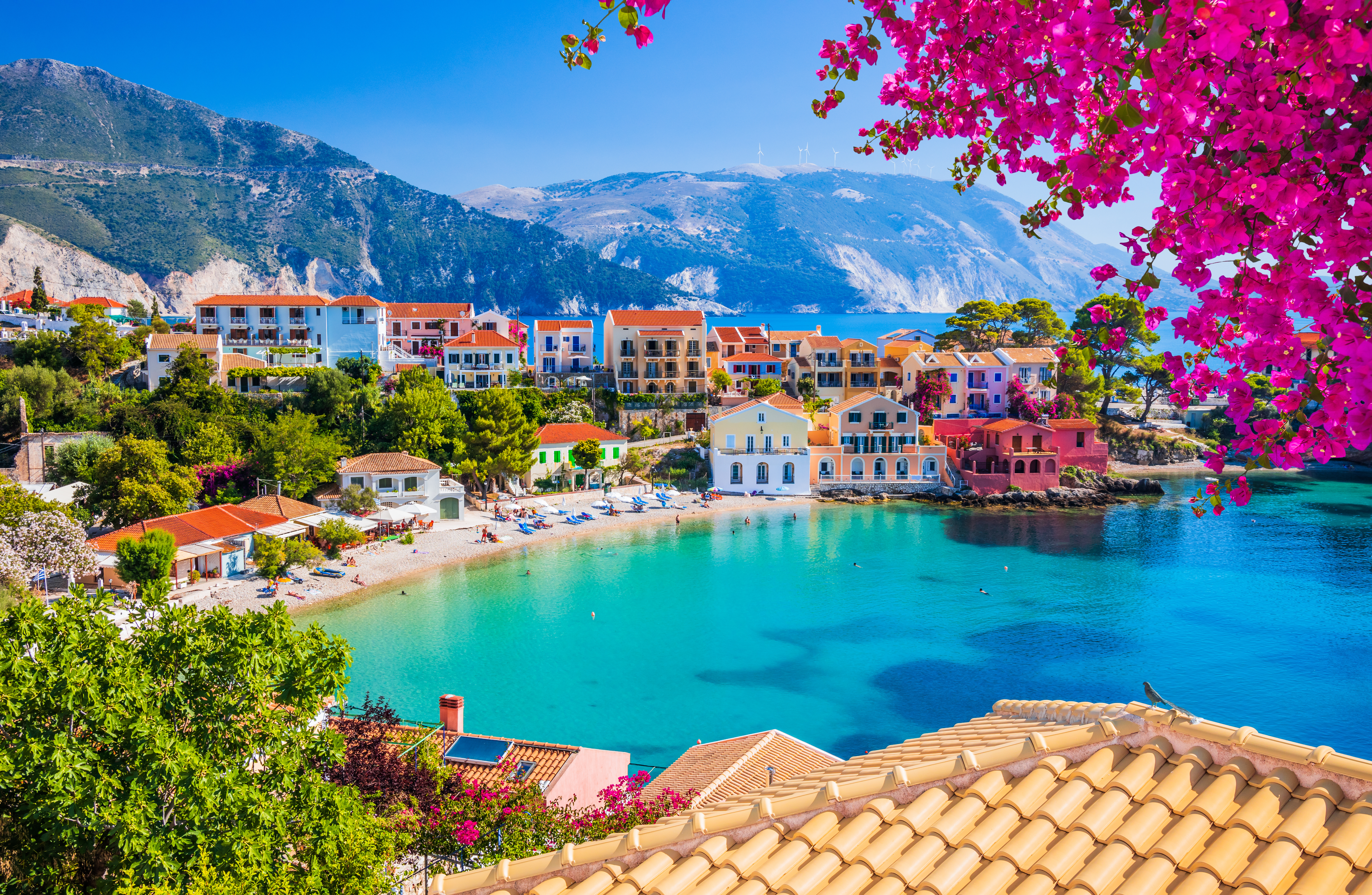Panoramaudsigt over det charmerende Assos på Kefalonia, Grækenland, med azurblåt vand og farverige bygninger ved kysten