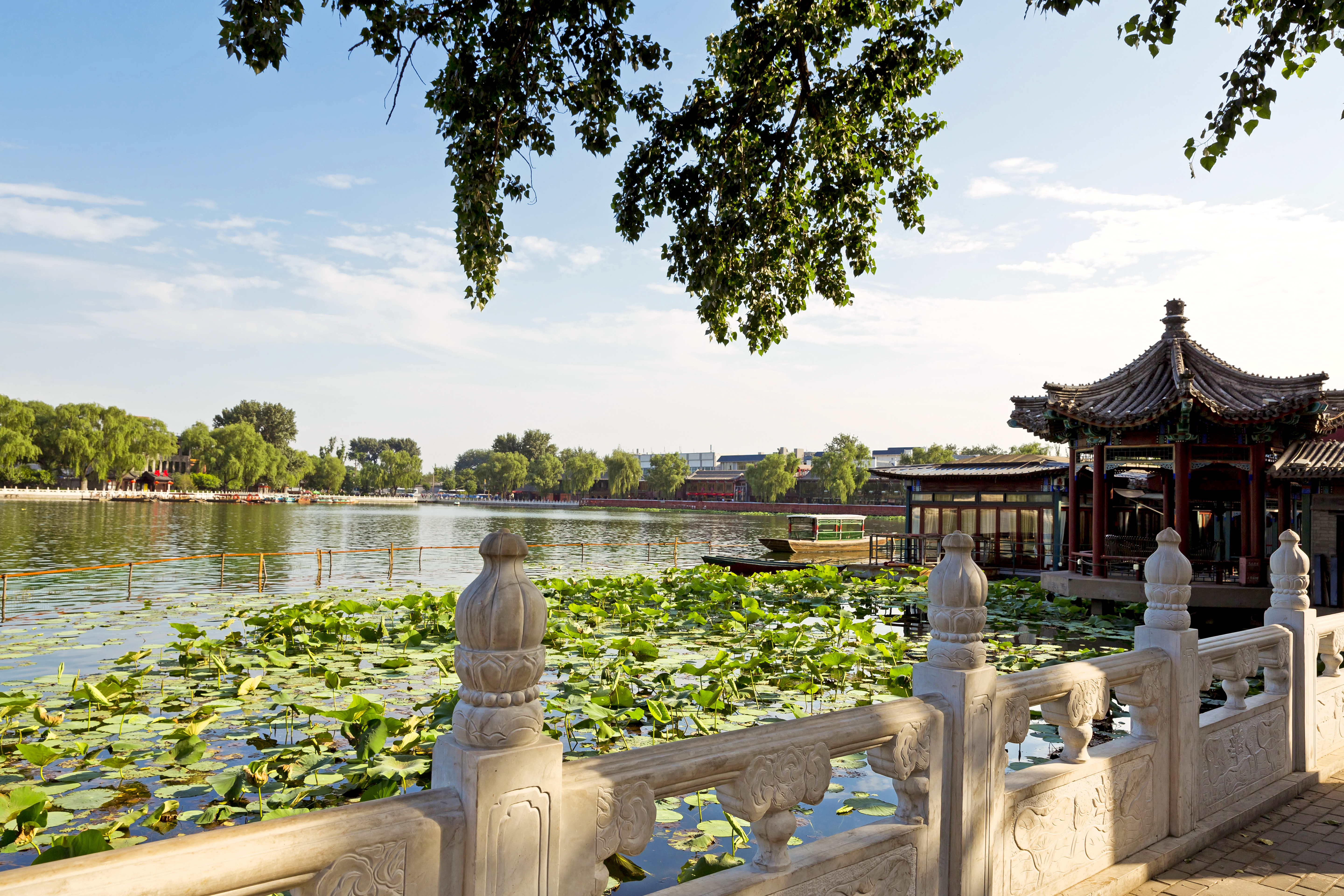 Historisk kinesisk pavillon og stengelænder ved lotusdammen i Beijing Houhai-området