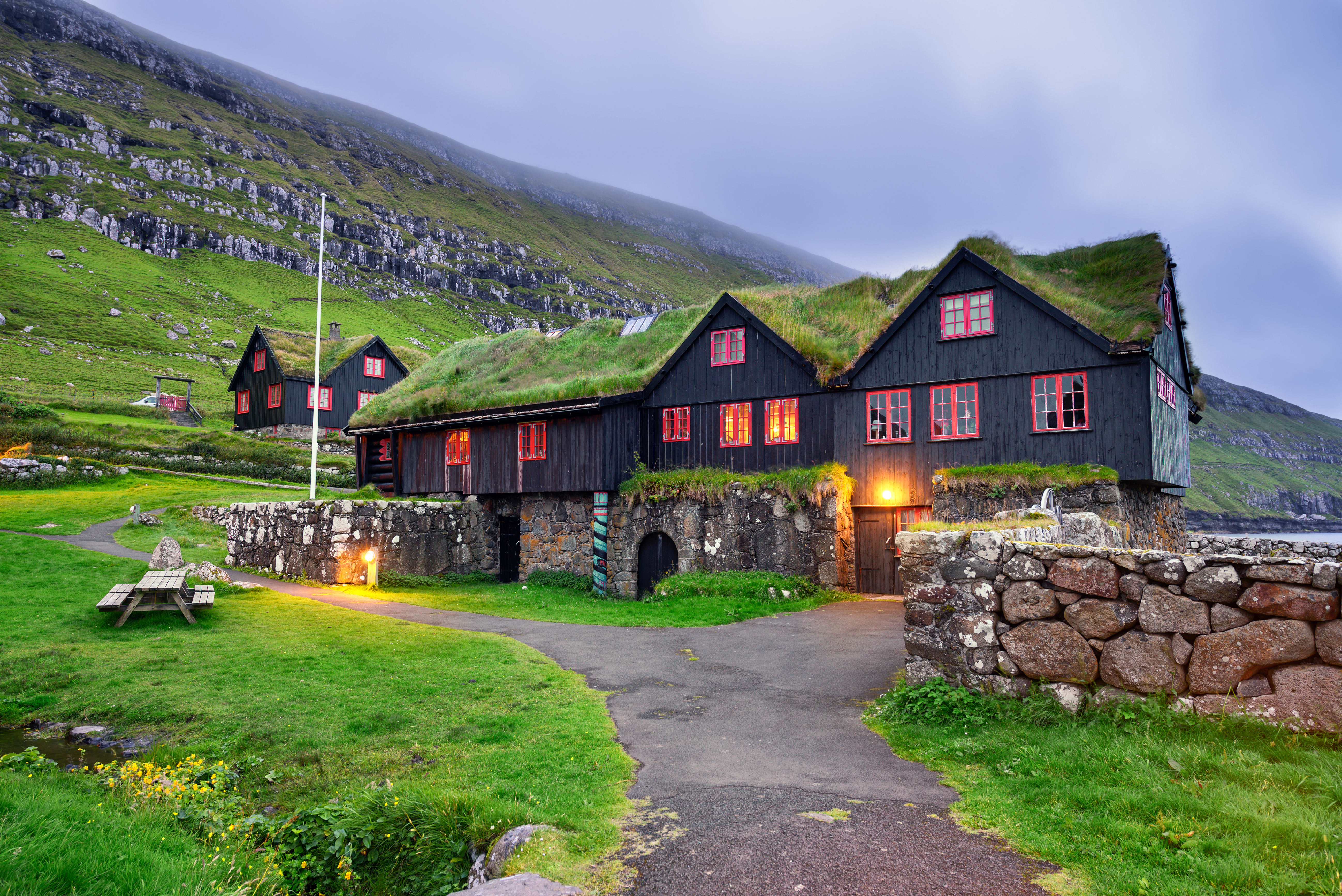 Traditionelle færøske huse i Kirkjubour landsby med græstag om aftenen