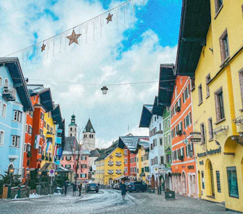 Historisk bymidte i Kitzbühel med karakteristiske farverige bygninger og brolagt gade om vinteren i Østrig