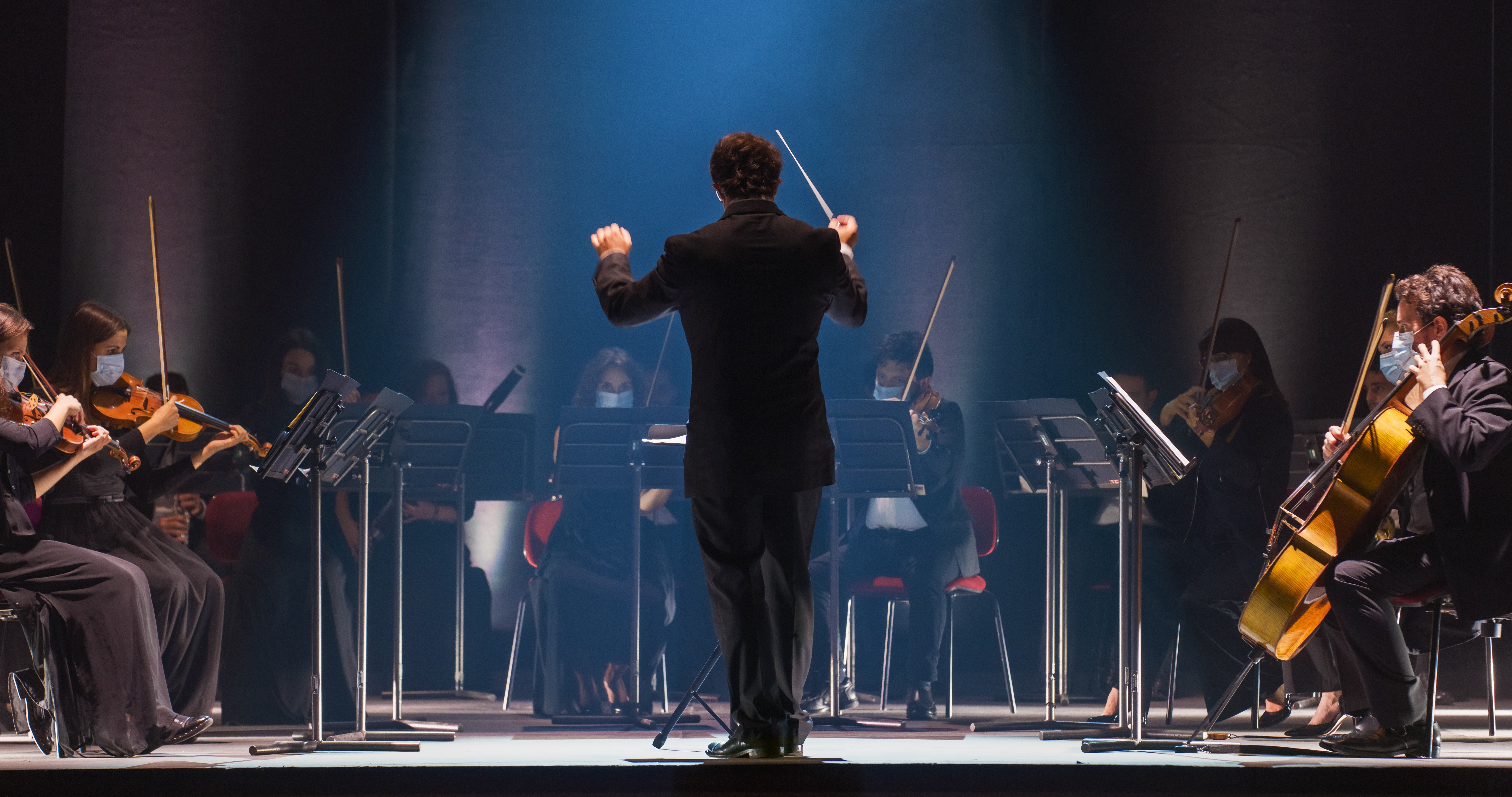 Klassisk musikorkester med dirigent i elegant koncertsal under live performance