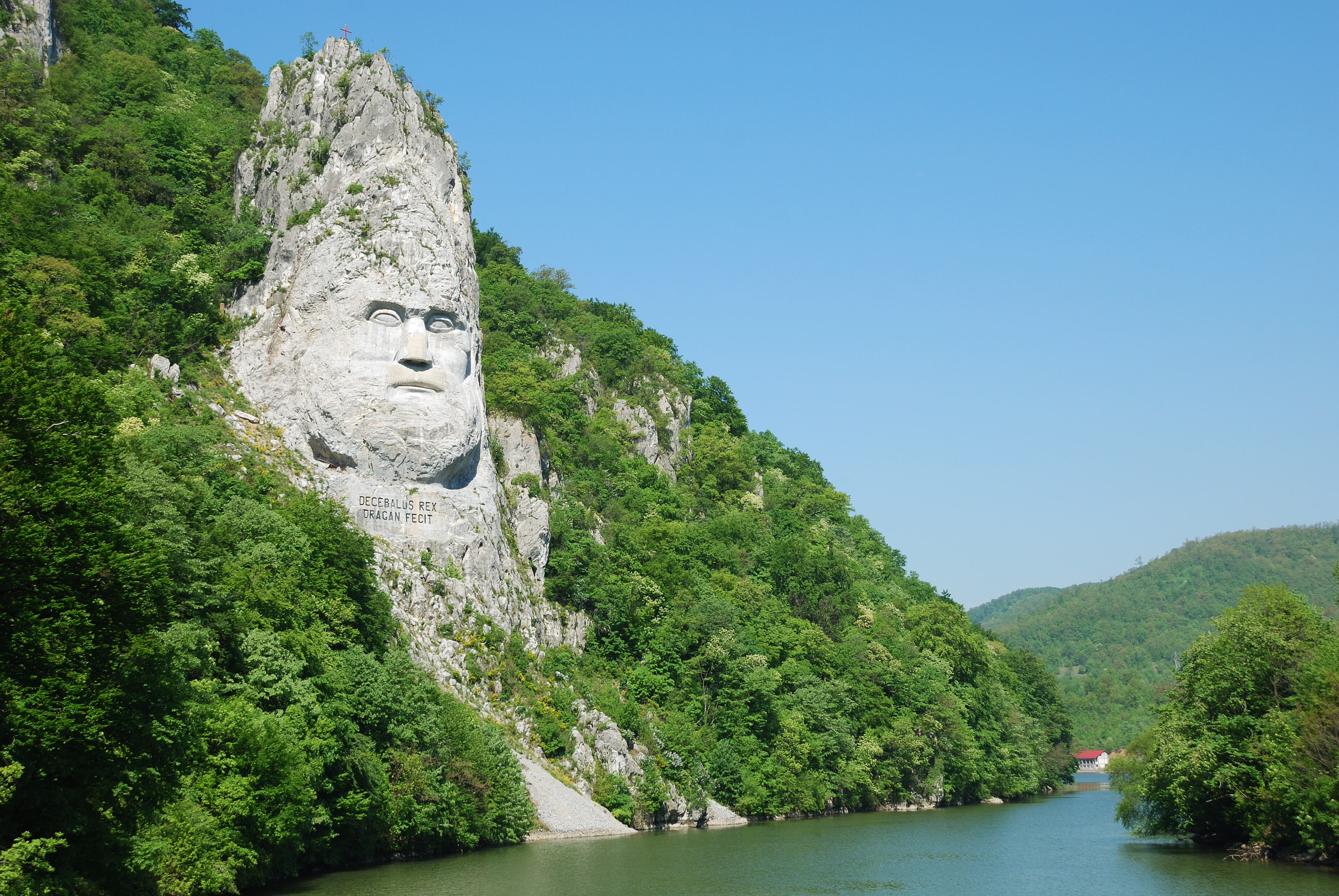Klippeskulptur af Decebalus i naturskønt område ved flod i Rumænien