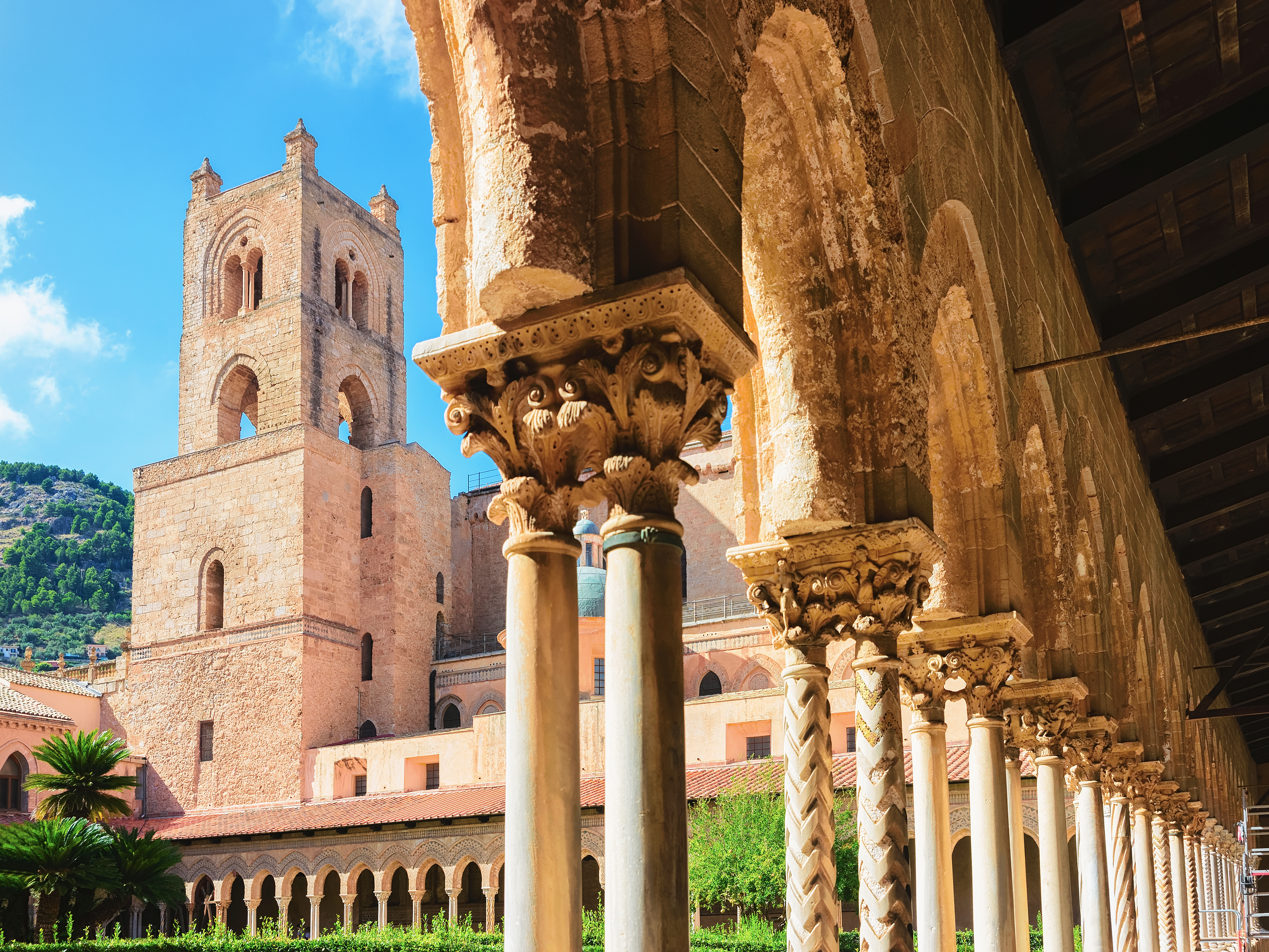 Imponerende søjlegang i den historiske klosterhave ved Monreale-katedralen på Sicilien - et unikt eksempel på middelalderlig arkitektur fra 1100-tallet