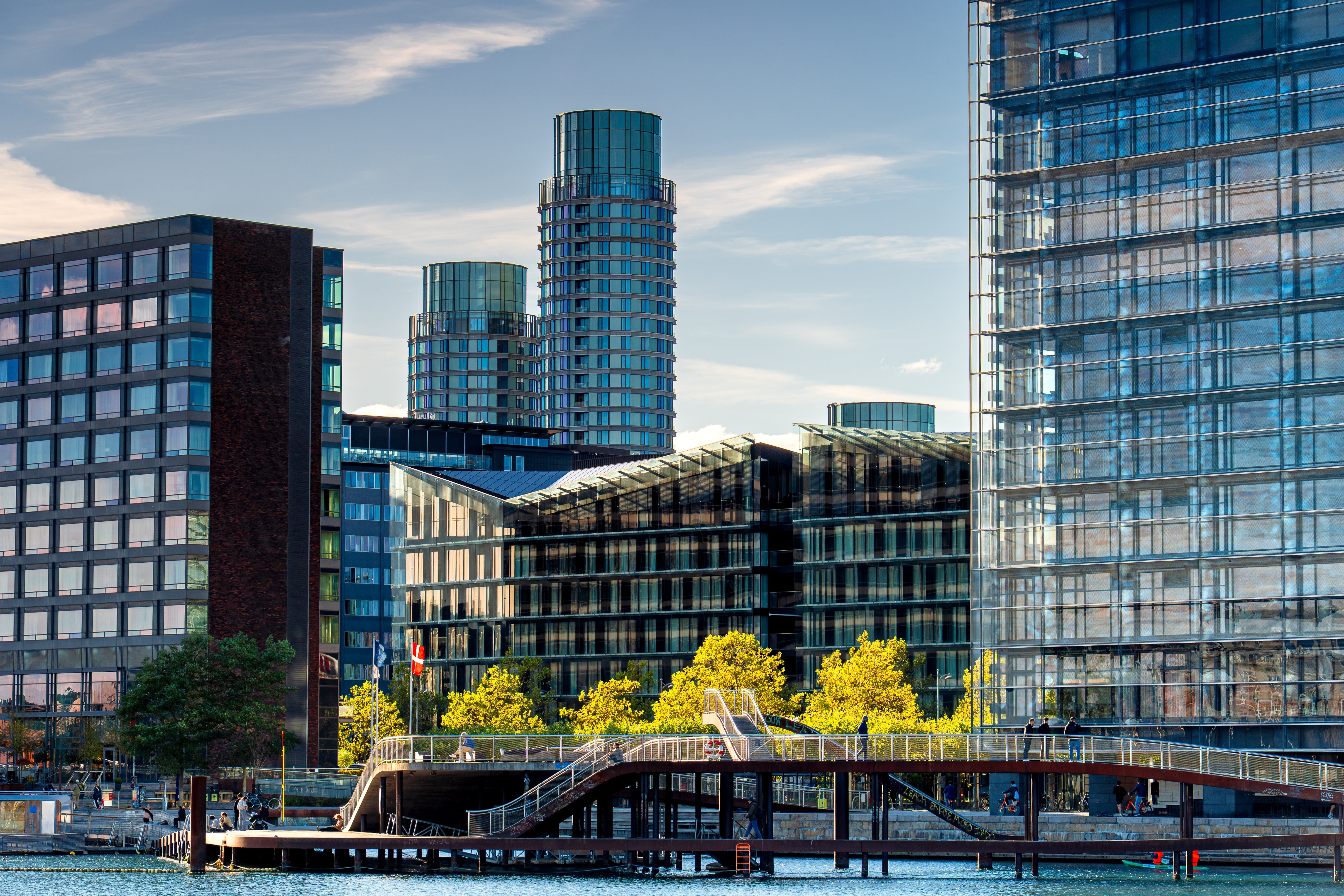 Moderne arkitektur og skyline ved Havnestad i København med glasskyscrapere og gangbro over vandet