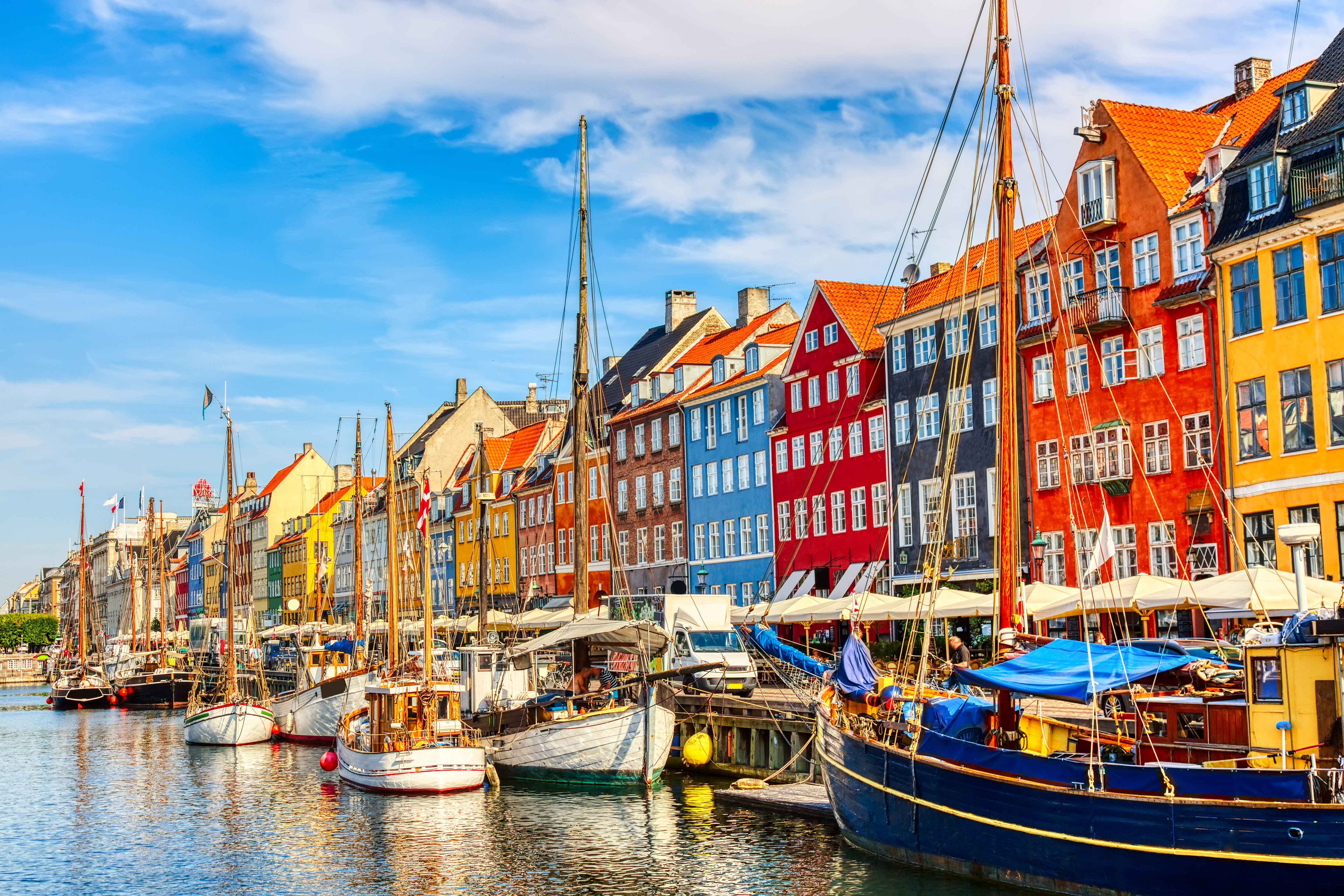Idyllisk udsigt over Nyhavns kanal med farvestrålende bygningsfacader og fortøjede både i Københavns charmerende havnemiljø