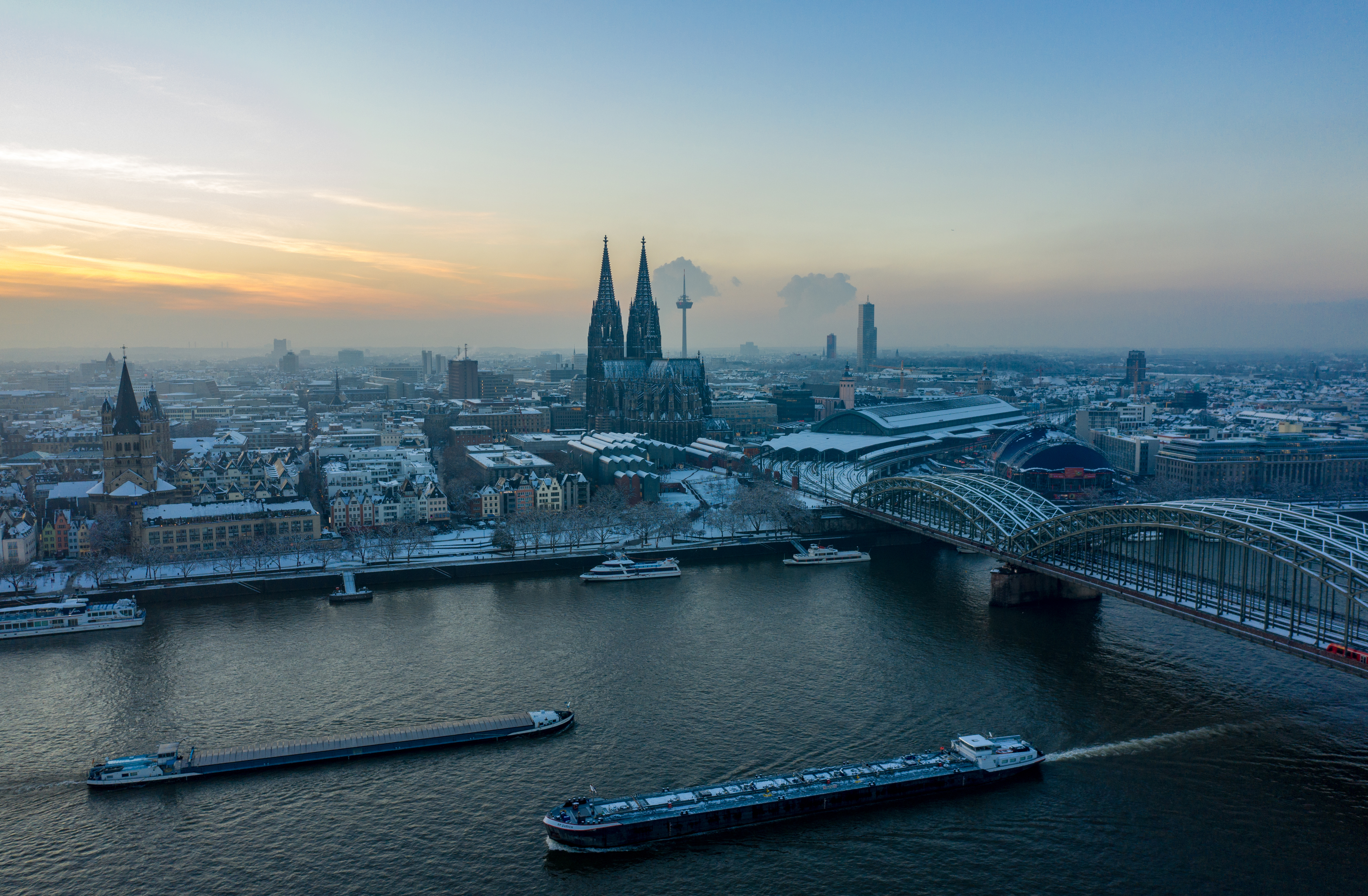Spektakulær udsigt over Köln med domkirken og Rhinen i vinterlys ved solnedgang